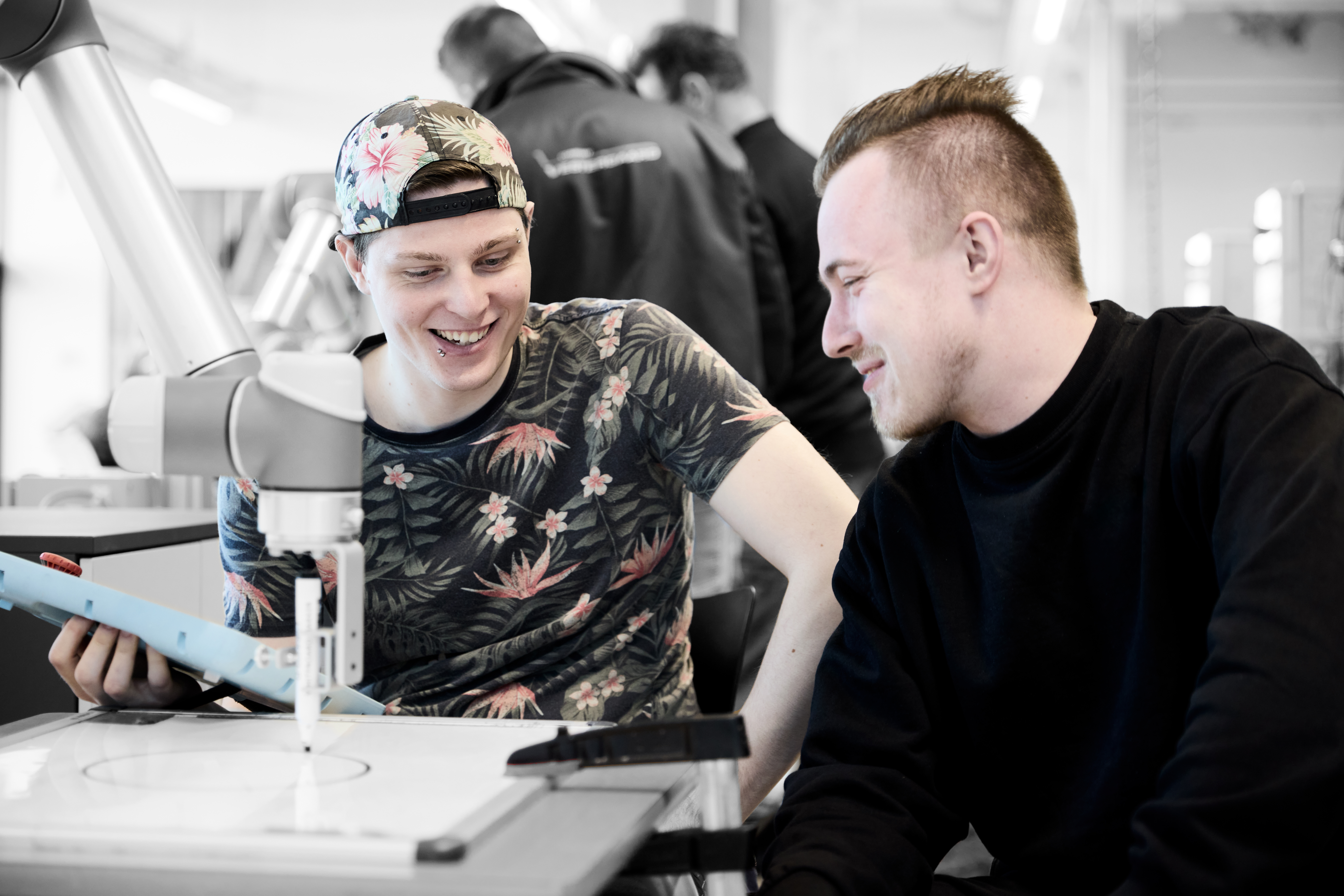 Automatikteknikere programmerer en robotarm