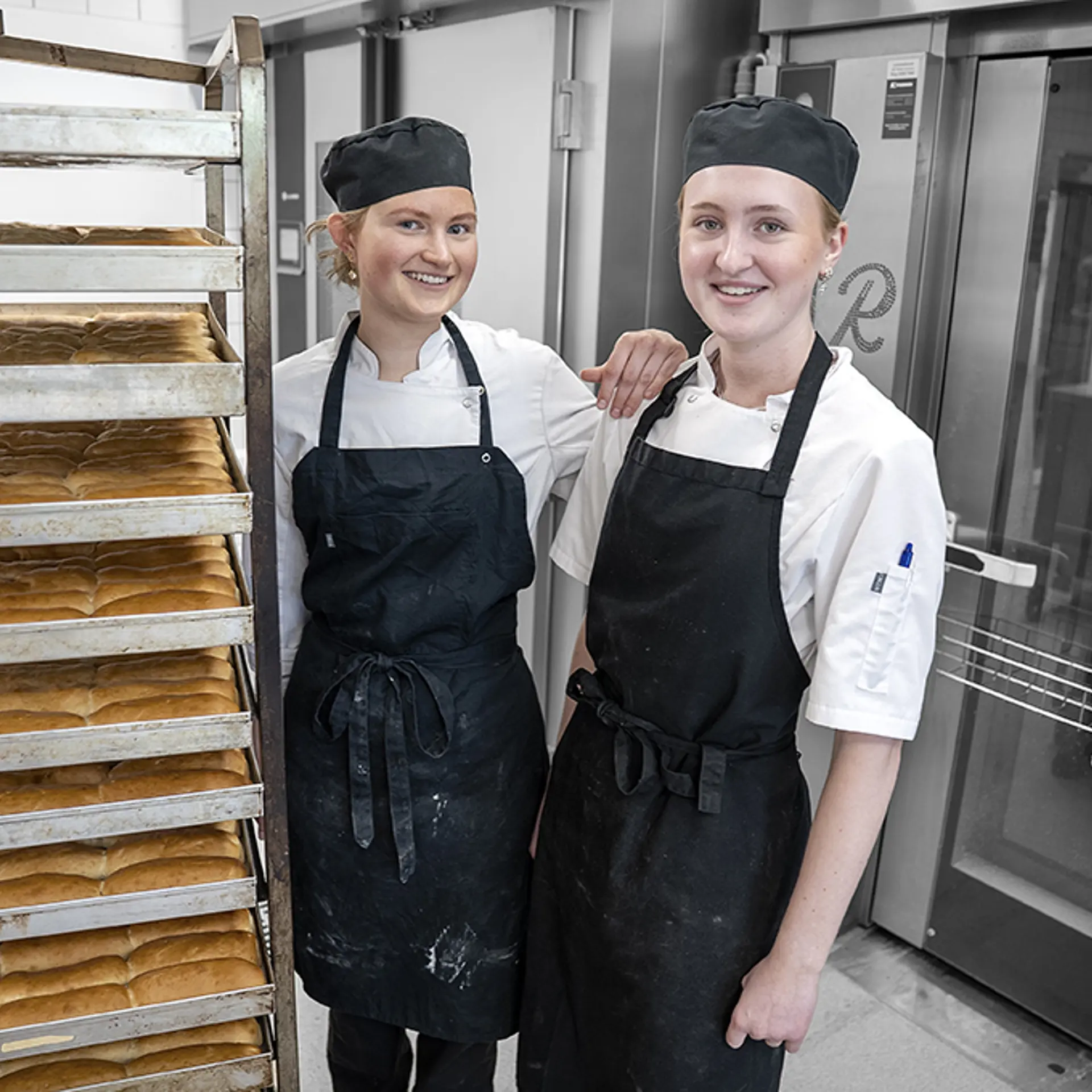 Elever På Bager Og Konditoruddannelsen Står med Friskbagt Brød