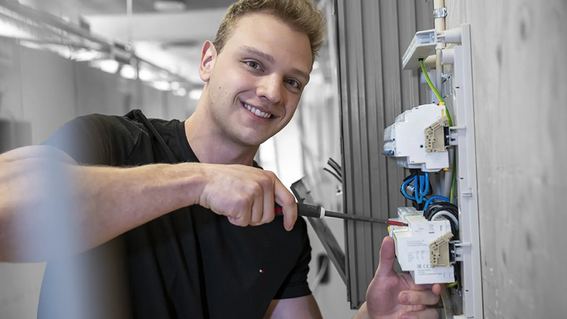 Elev På Elektrikeruddannelsen står med skruetrækker