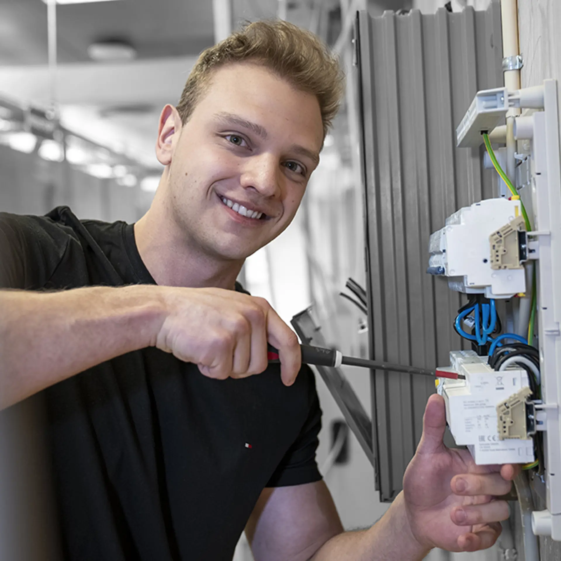 Elev På Elektrikeruddannelsen står med skruetrækker