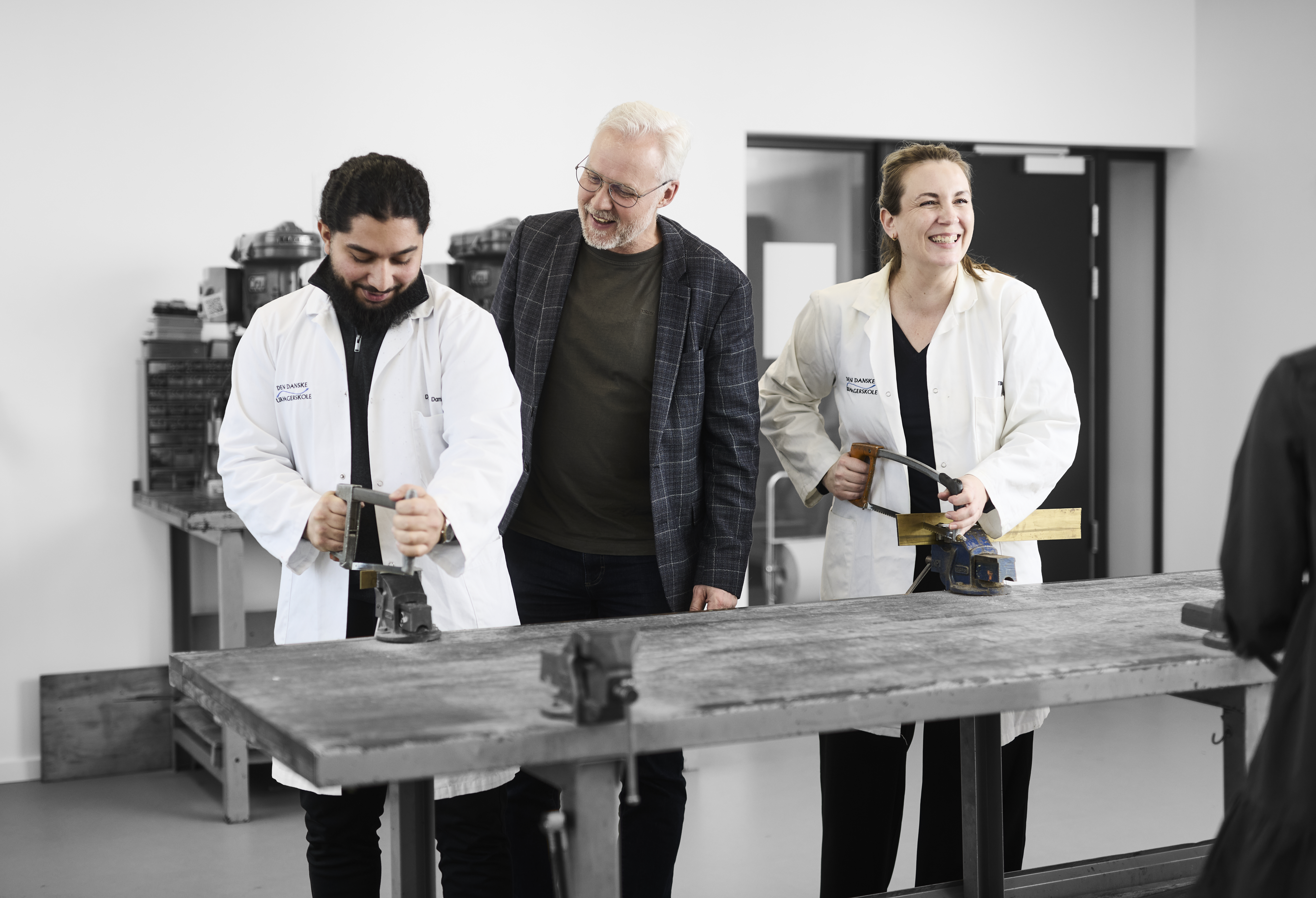 Urmagere og faglærer arbejder med forskellige værktøjer