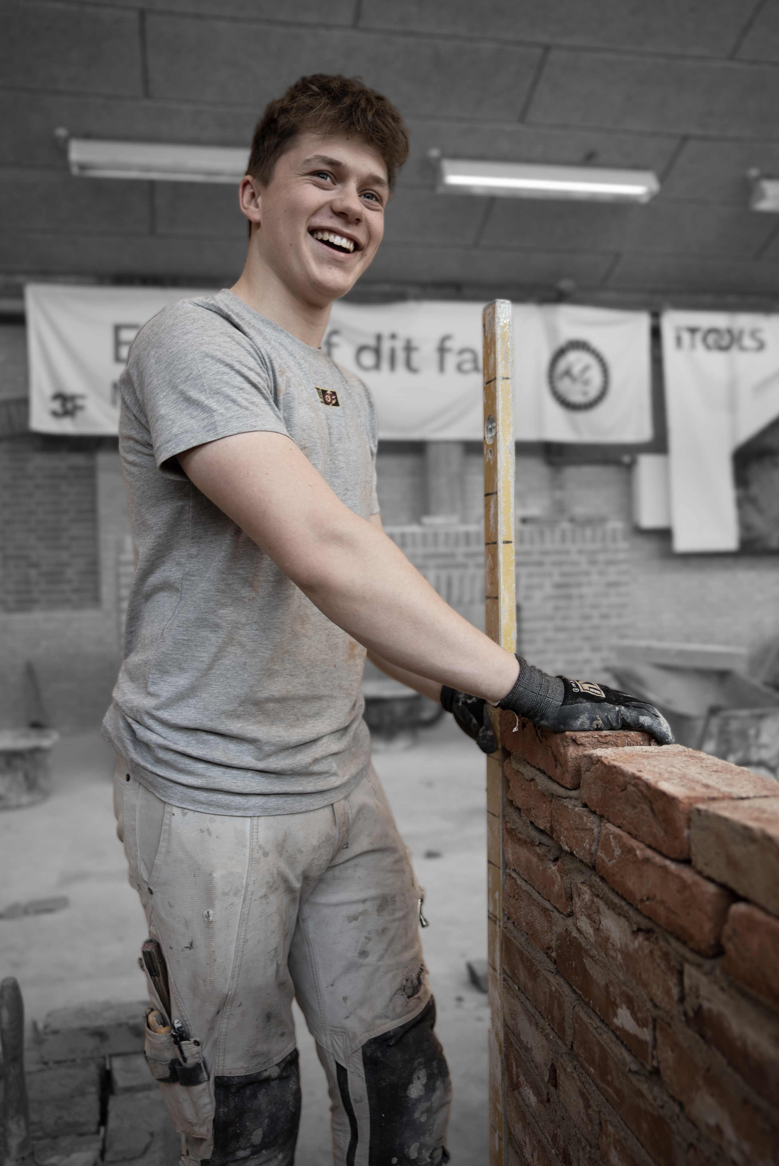 Elev på mureruddannelsen tjekker vater på mur