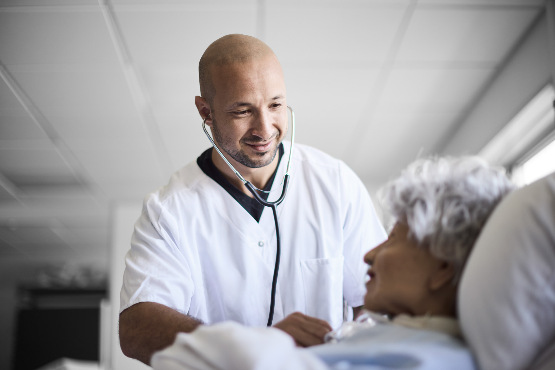 ZBC Roskilde social- og sundhedsuddannelserne - SOSU-assistent tilser patient i sengen med stetoskop
