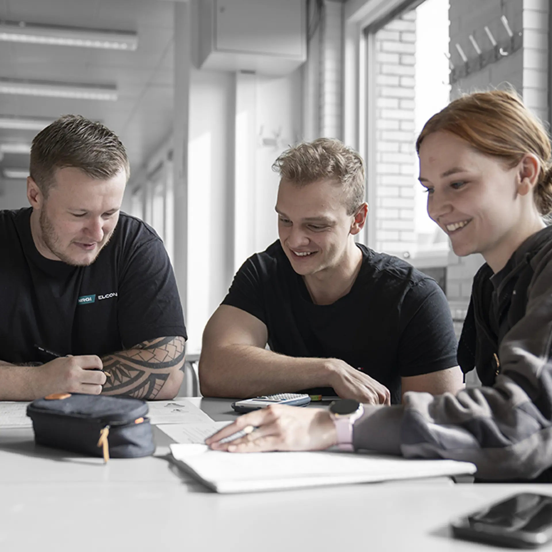 Tre elever fra elektrikeruddannelser sidder og har undervisning