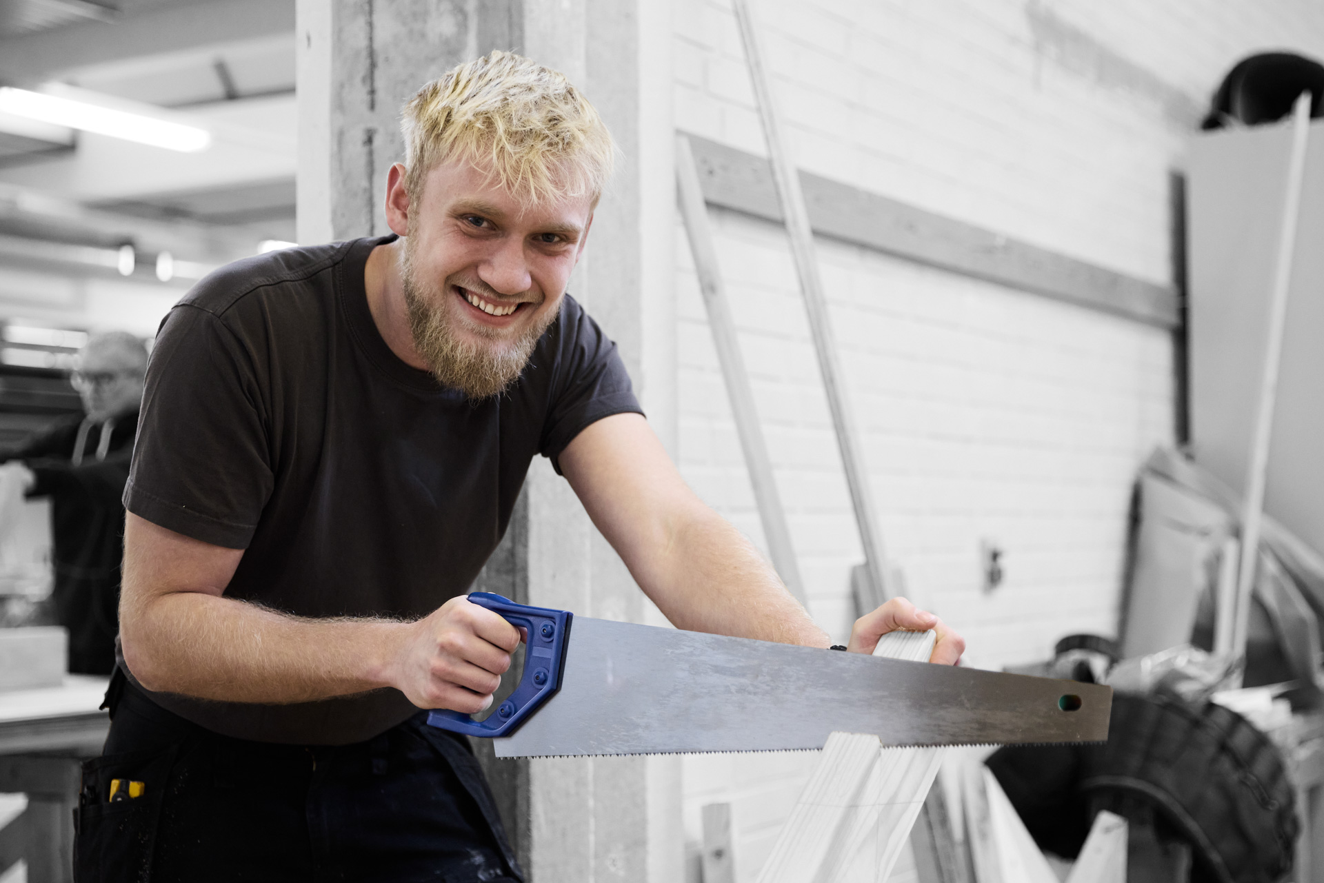Tømrer på værksted saver