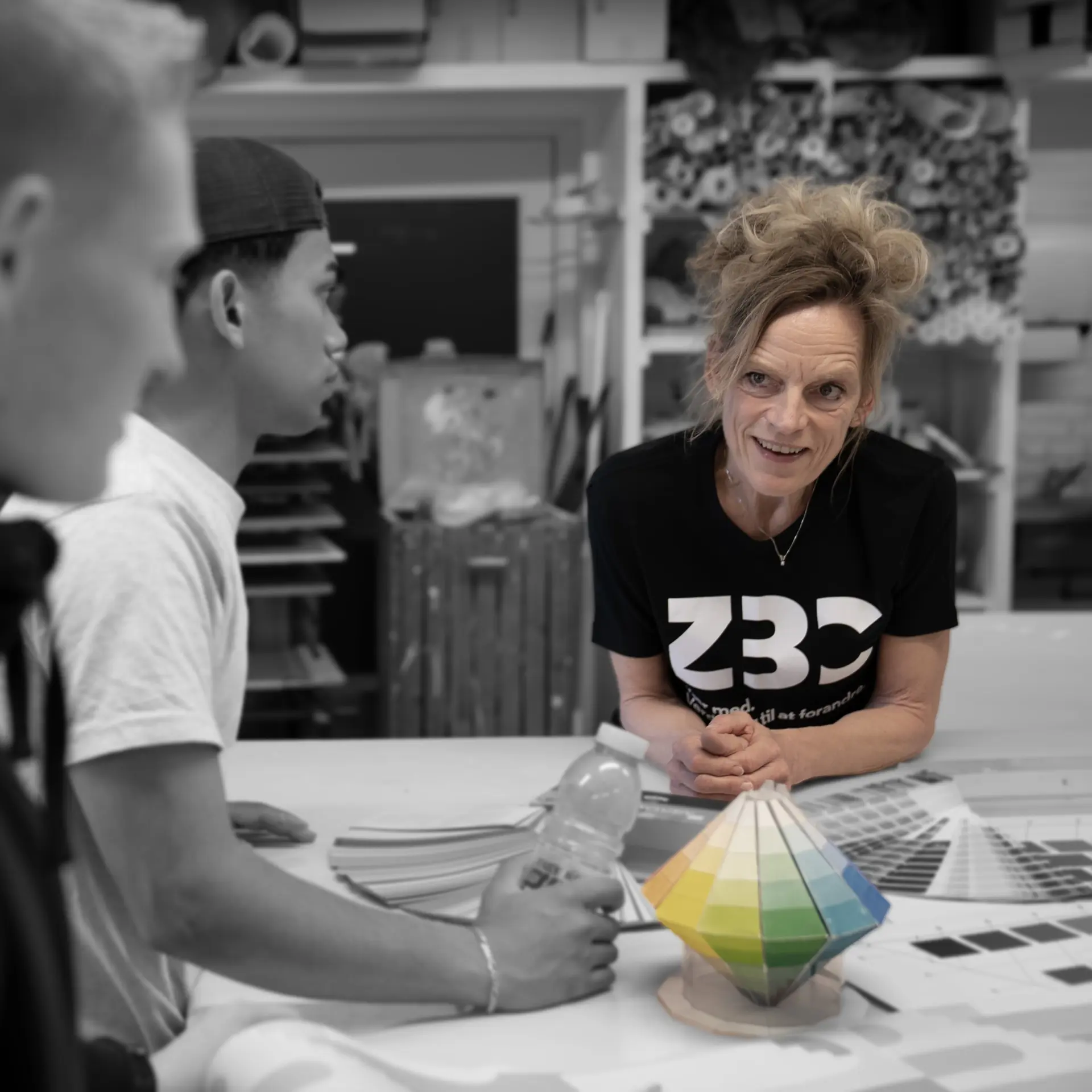 Bygningsmaler på værksted med to malerelever