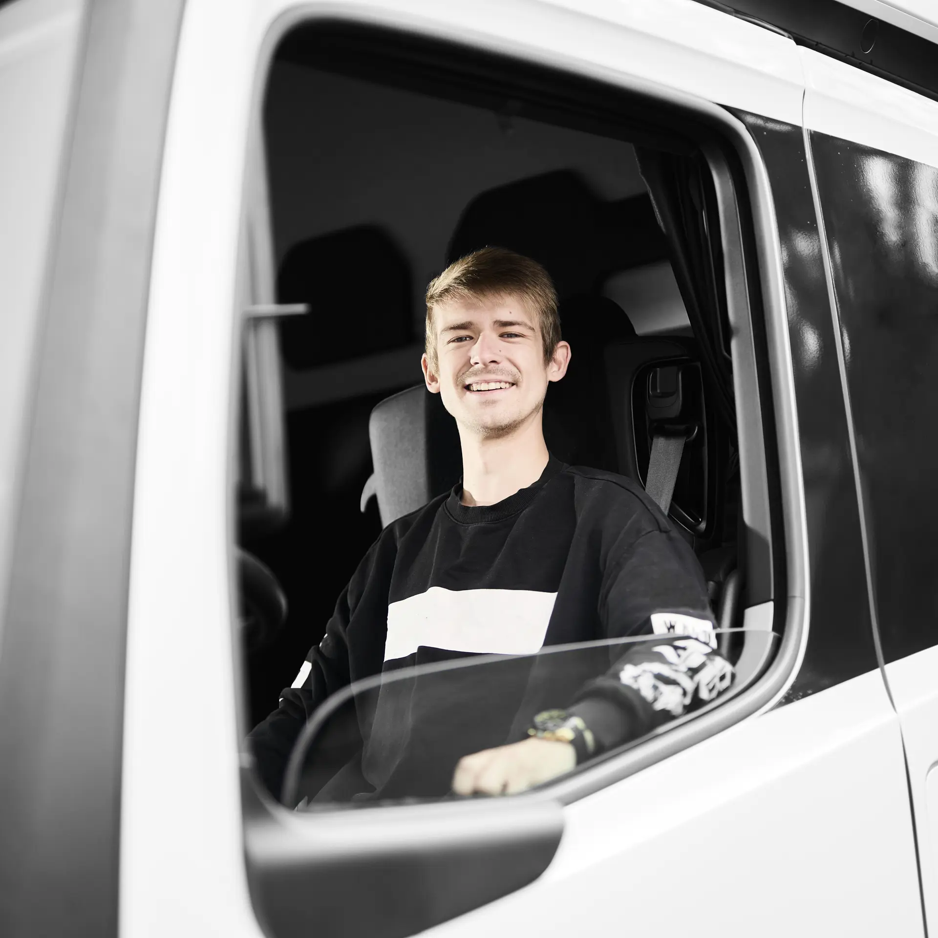 Vejgodstransport-elev sidder i lastbilens førerhus