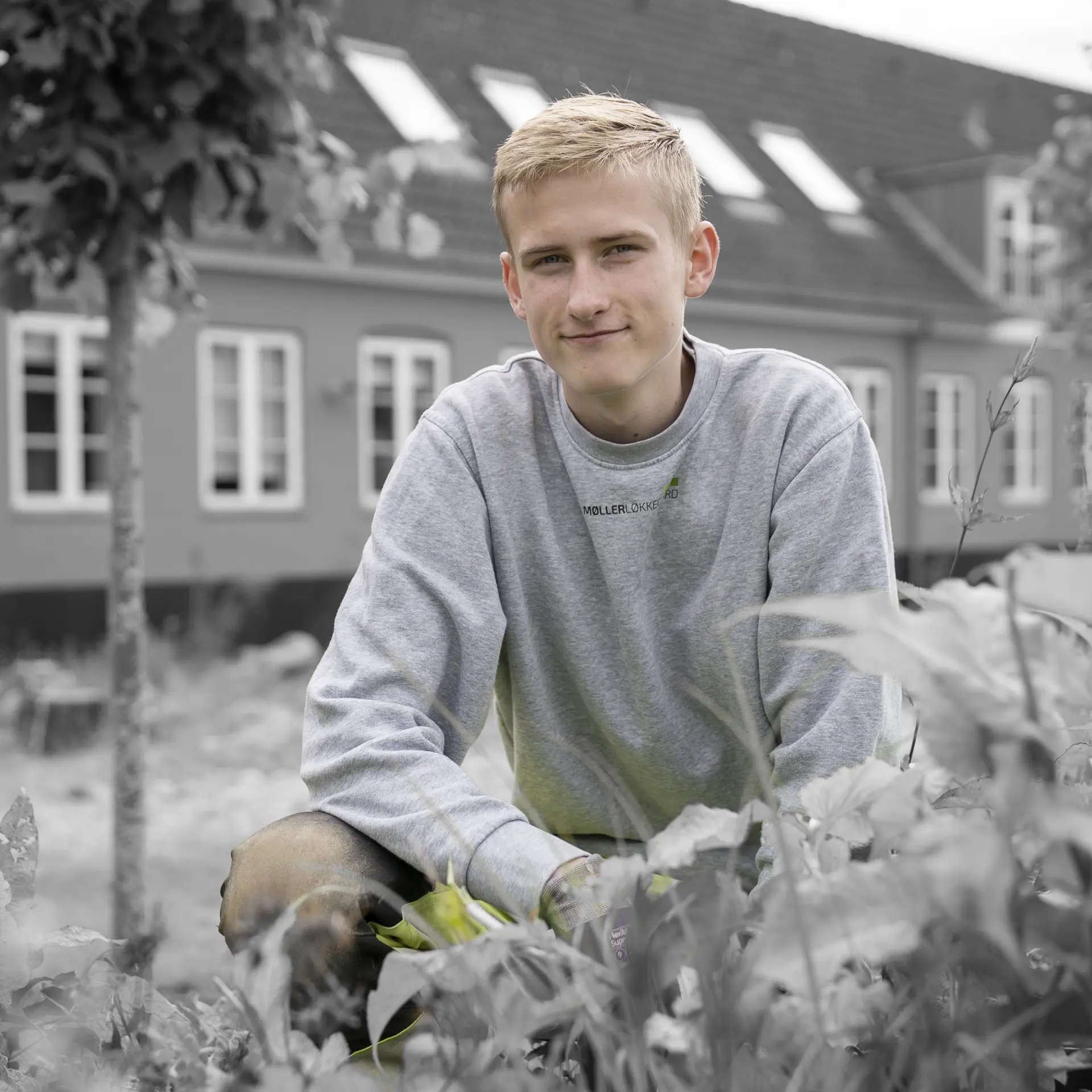 Anlægsgartnerelev sidder ved bed
