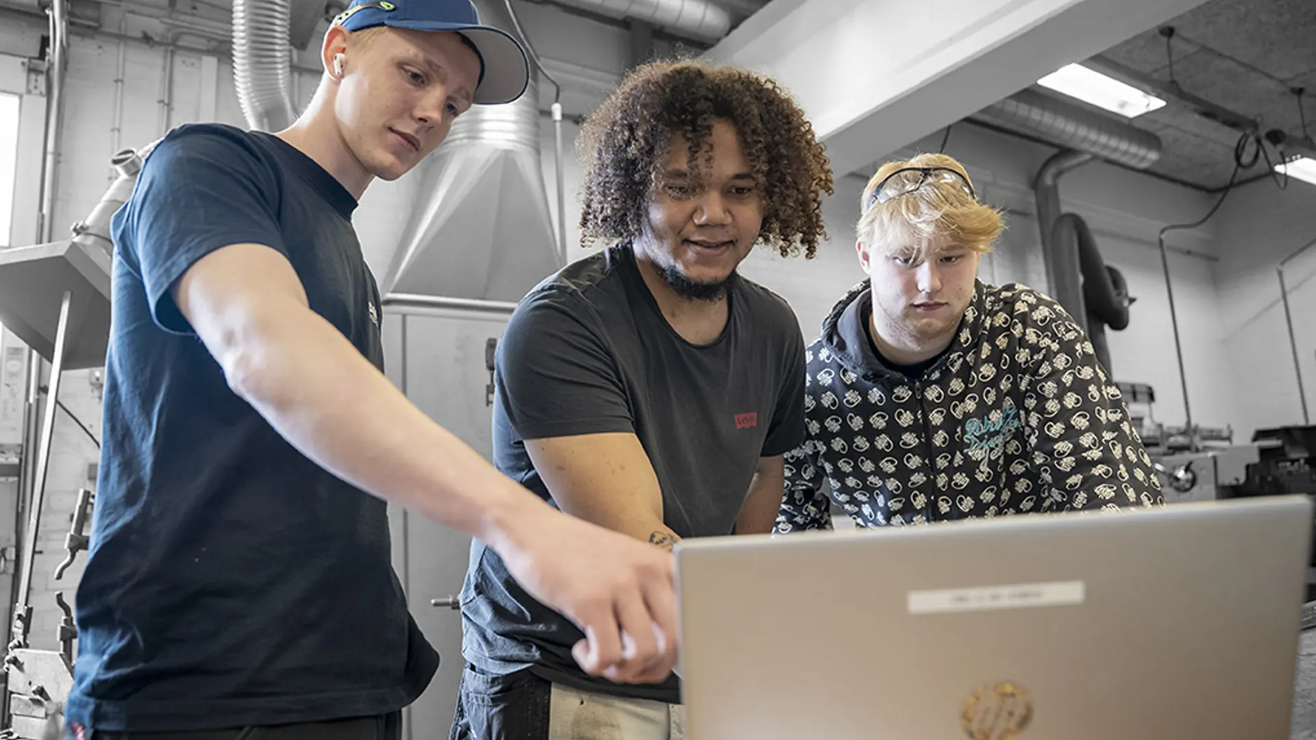 Elever på industriteknikeruddannelsen står i værksted