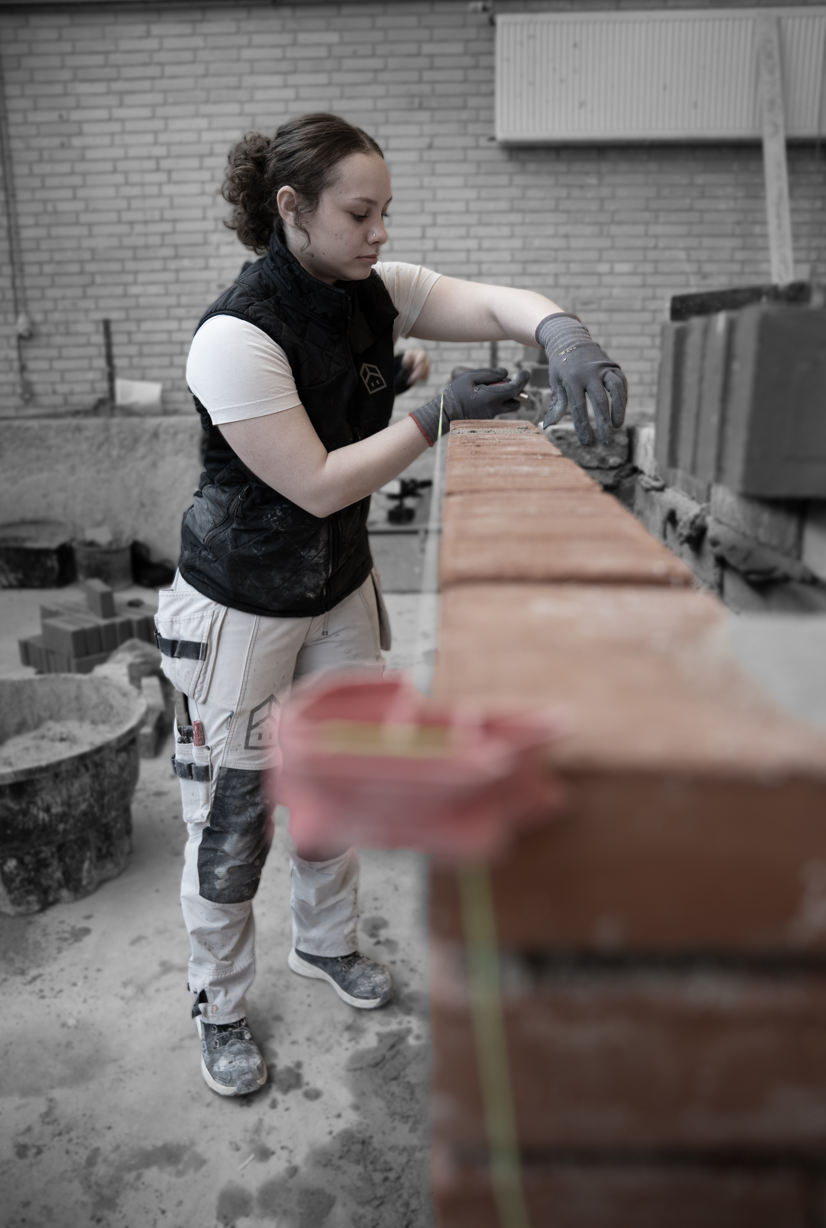 Elev på uddannelsen til murer stabler mursten