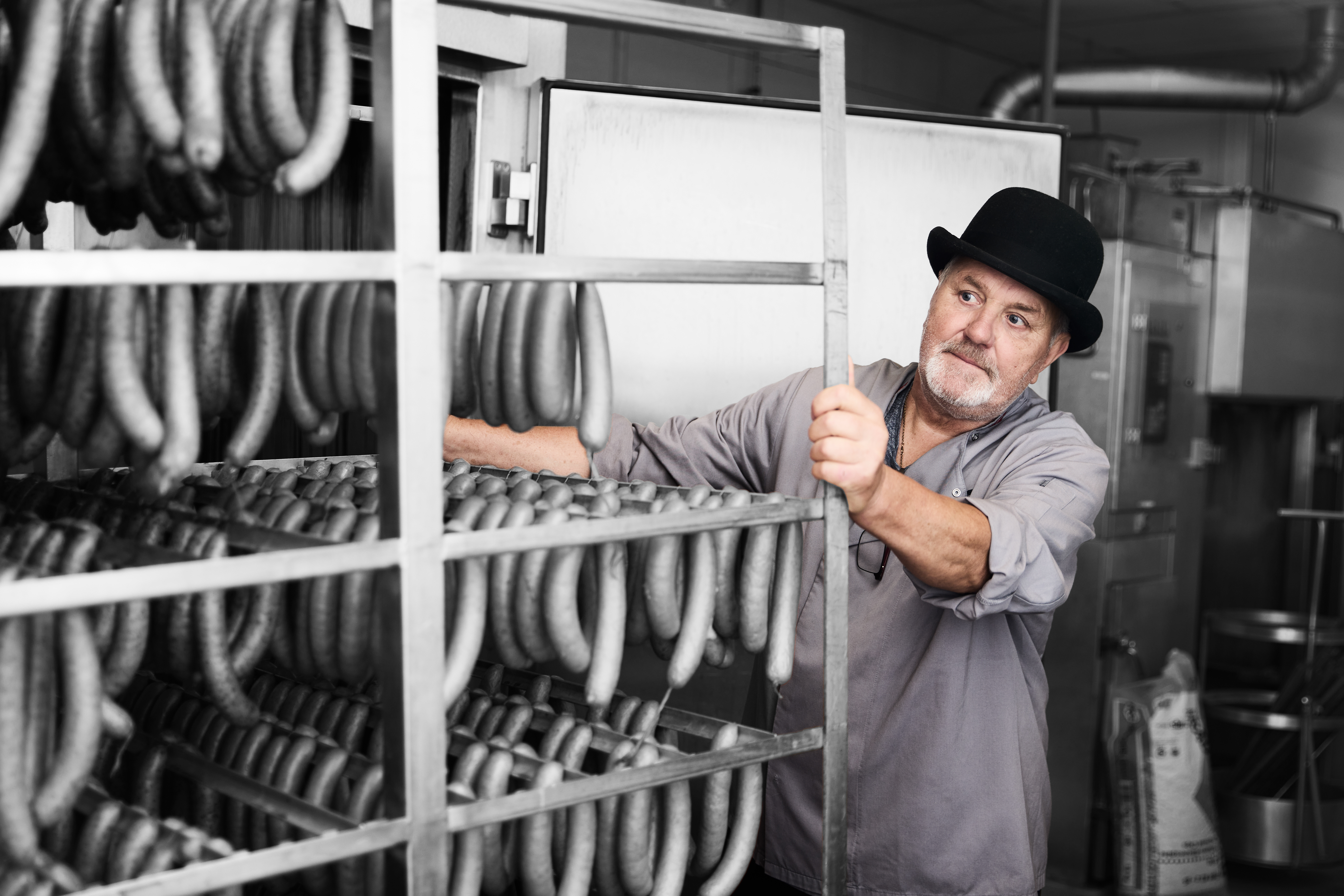 Gourmetslagter kører med et stativ med pølser