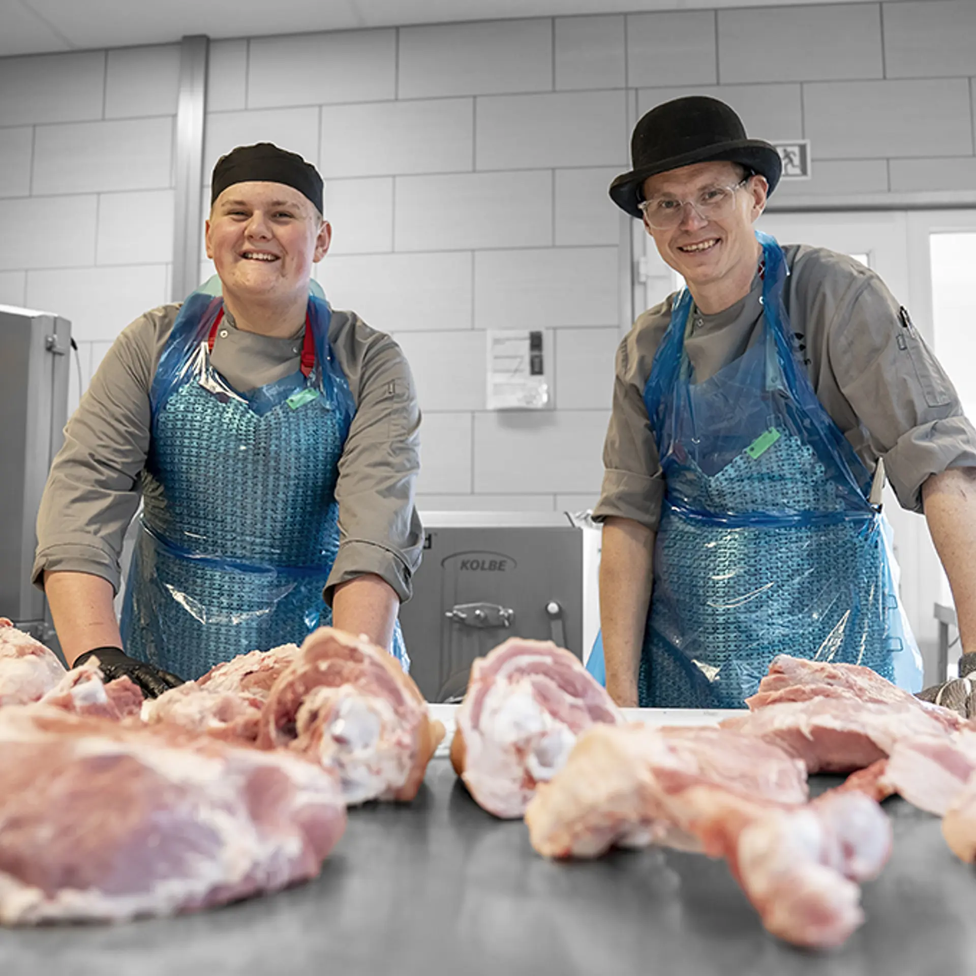 underviser og elev på Gourmetslagteruddannelsen arbejder med kødudskæring