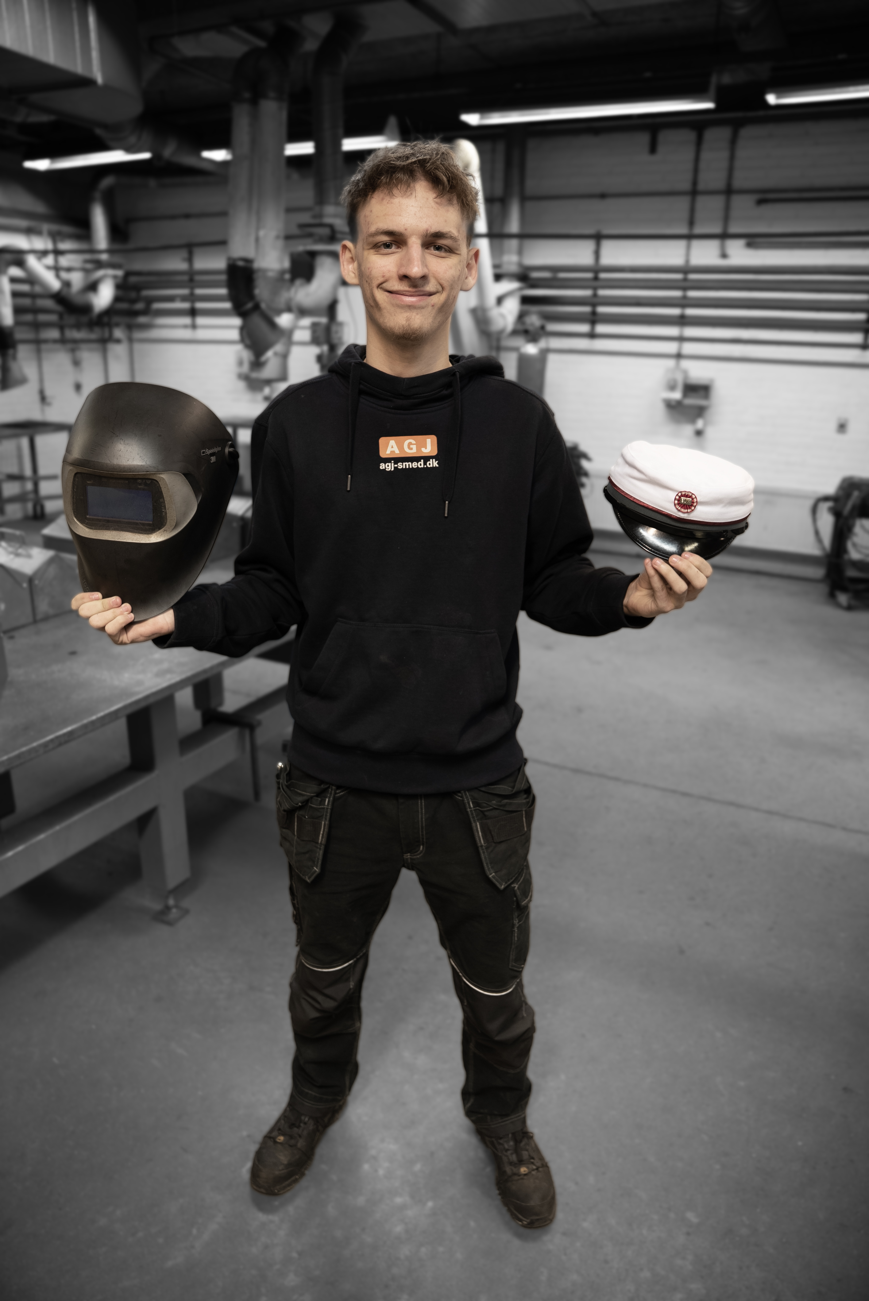 EUX-elev i smedeværksted med hjelm og studenterhue