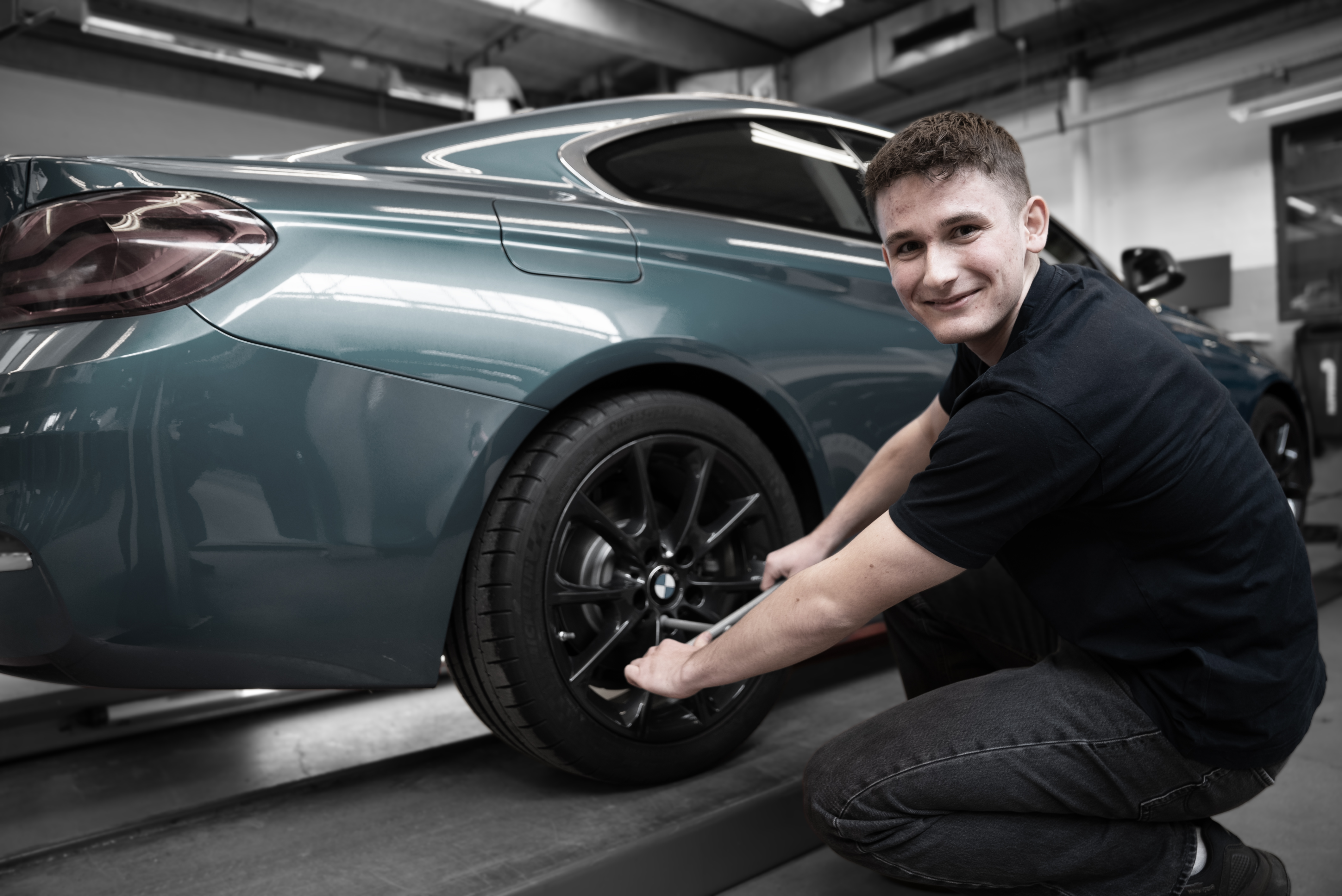 Elev på uddannelsen til mekaniker arbejder med dæk