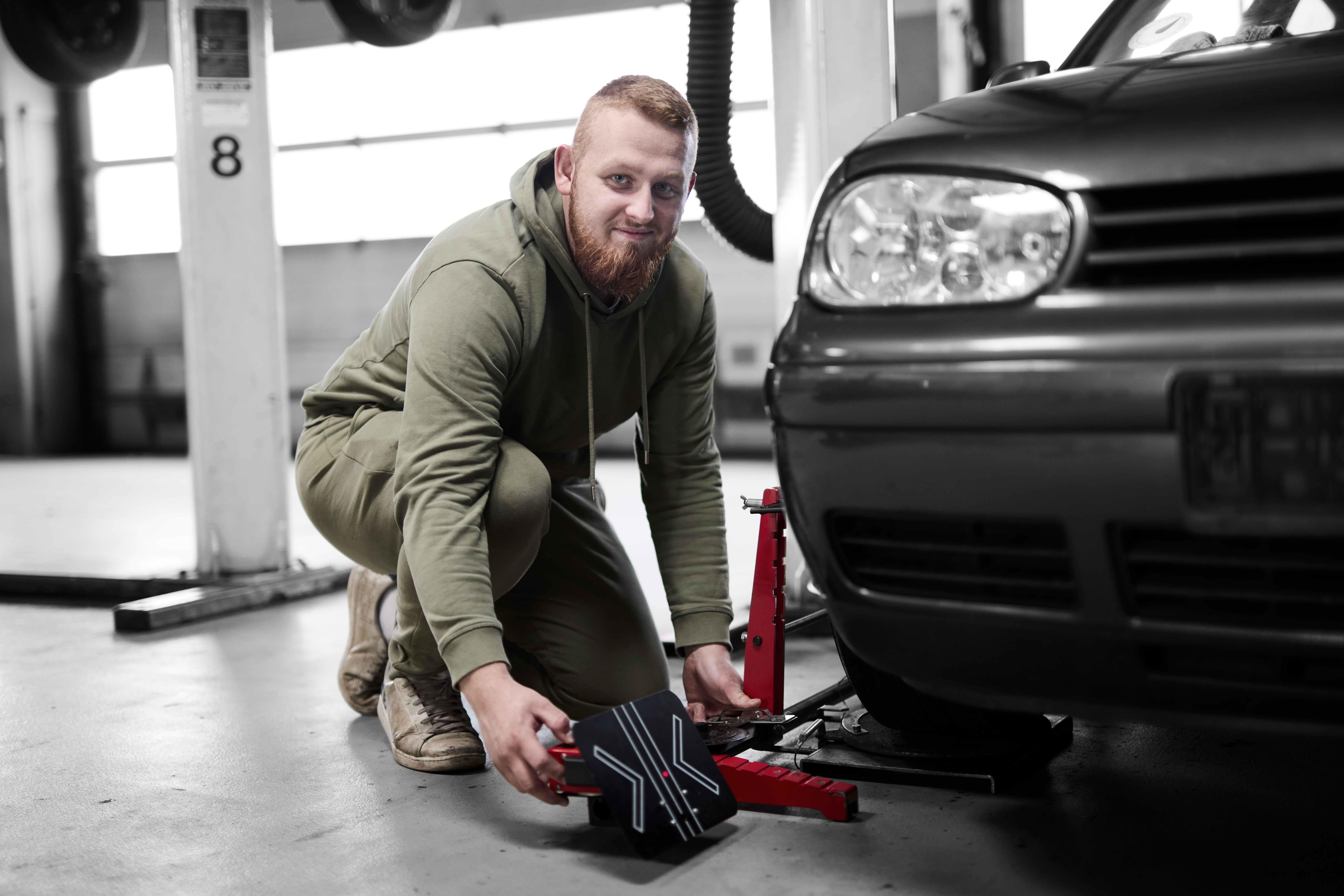 Mekaniker på værksted arbejder med en donkraft på en bil
