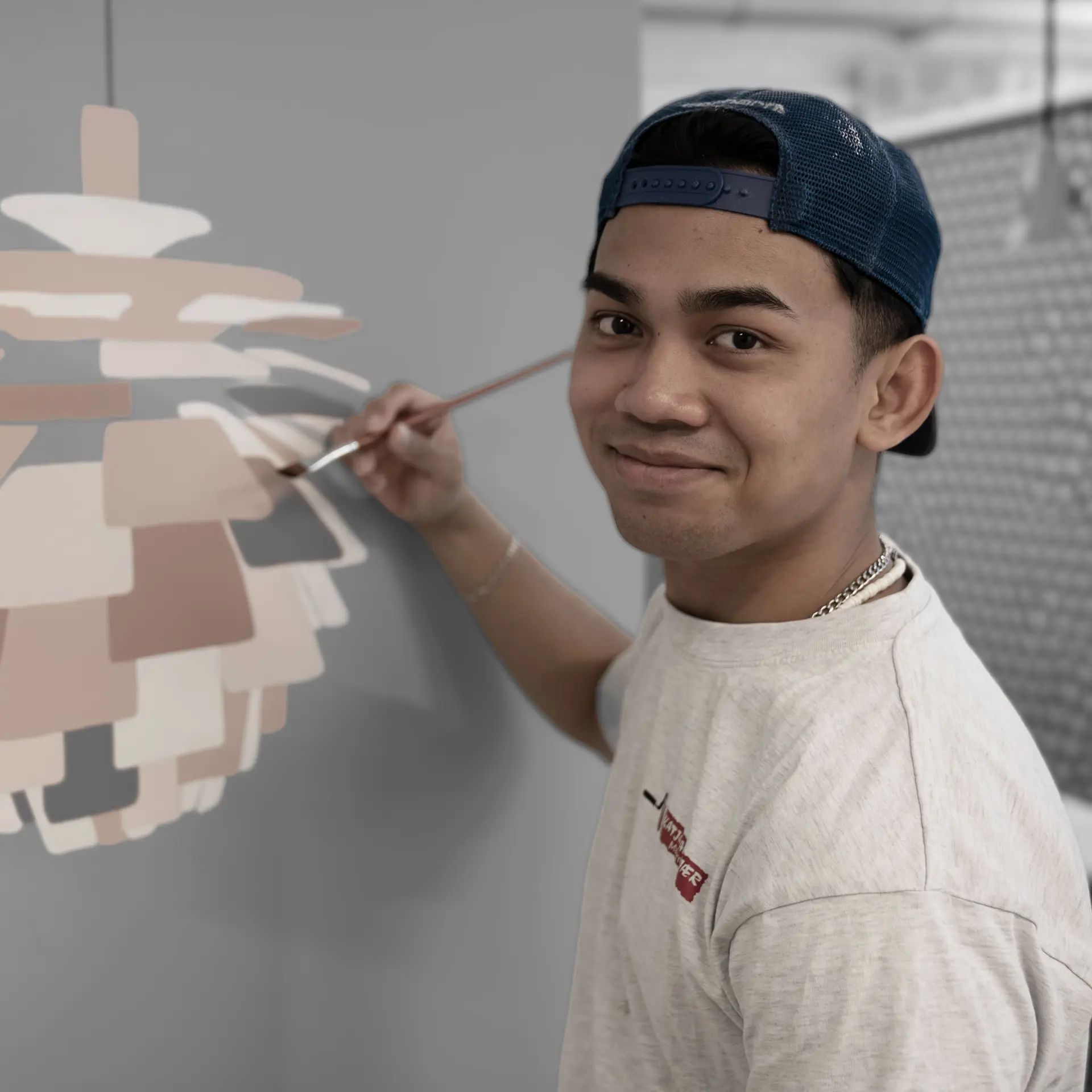 Bygningsmalerelev maler lampe på væg