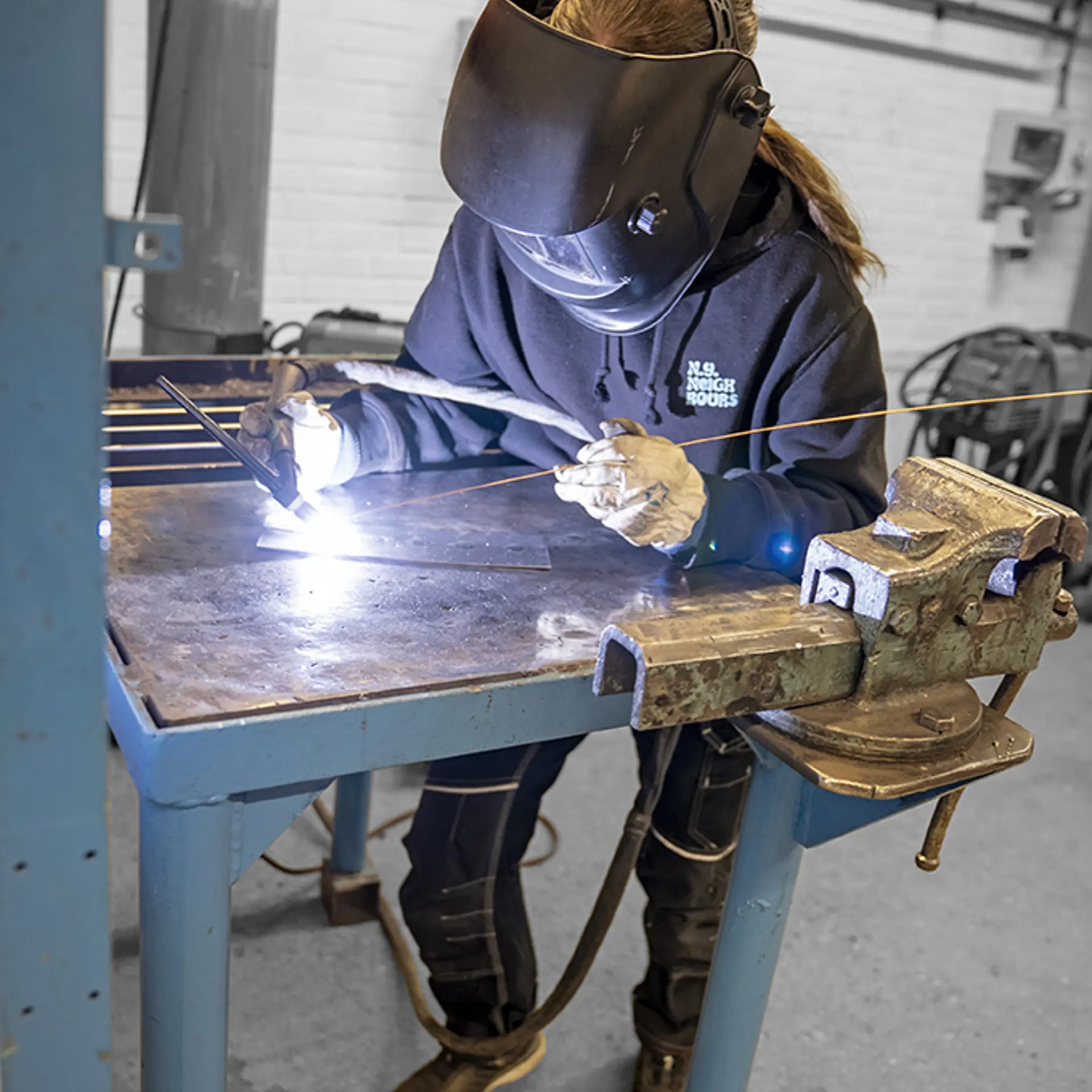 Elev fra uddannelsen til smed har beskyttelse på og svejser metal sammen