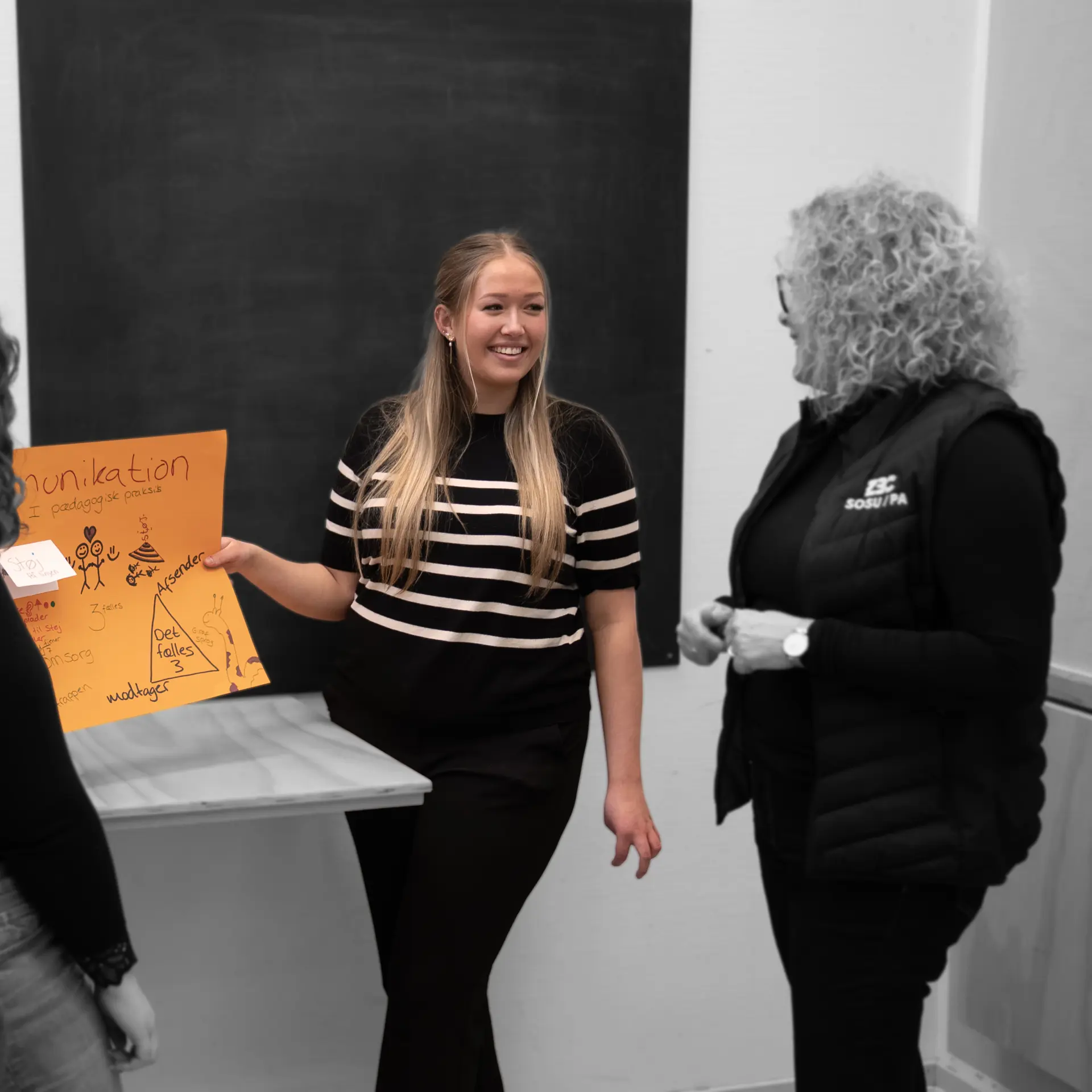 Elever på pædagogisk assistent præsenterer for underviser og smiler