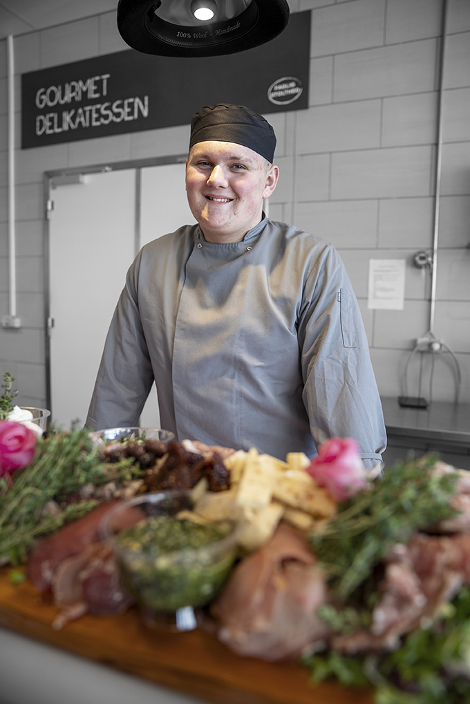 Elev på gourmetslagteruddannelsen arbejder med smørrebrød i køkkenet