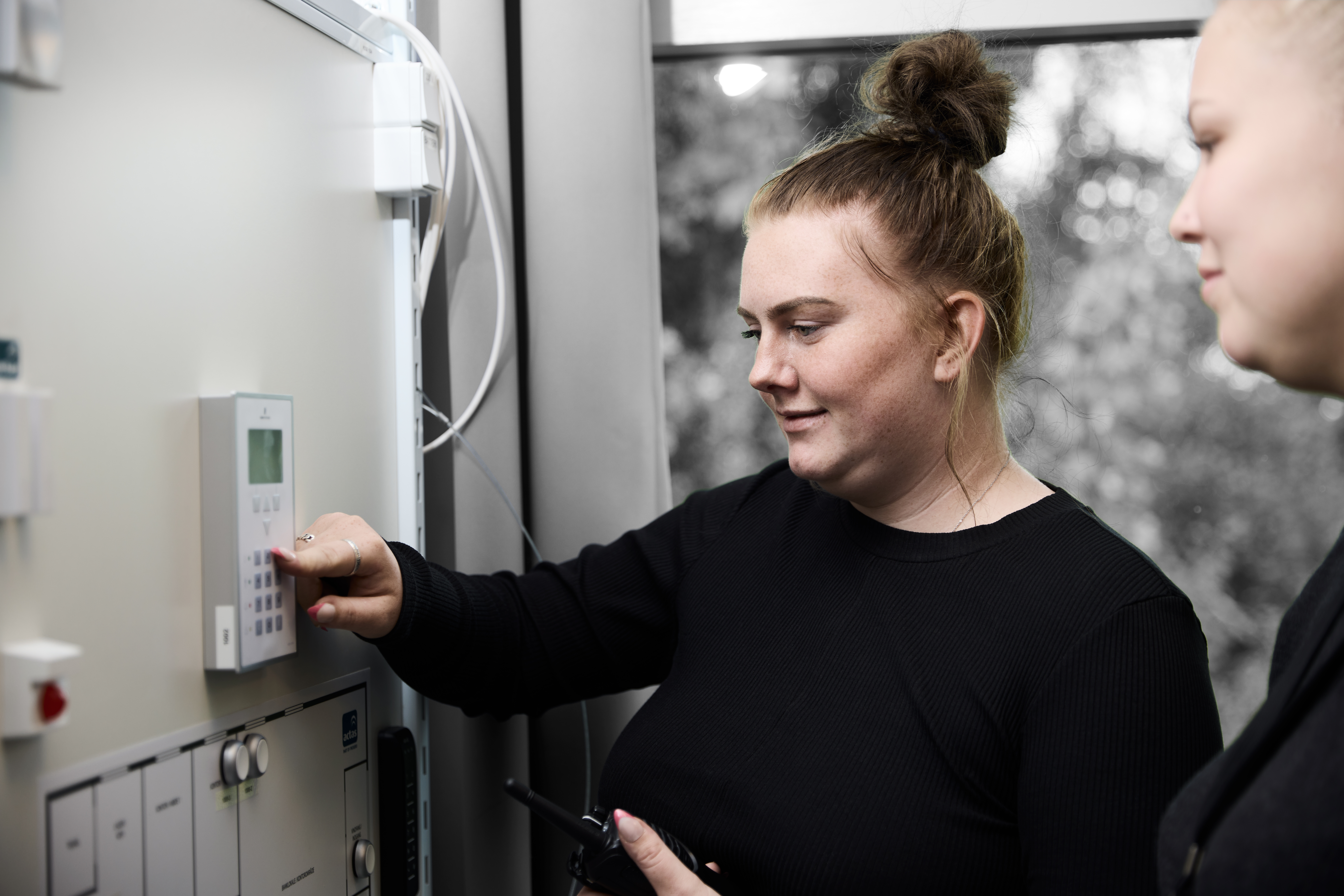 Sikkerhedsvagt står ved alarmsystem