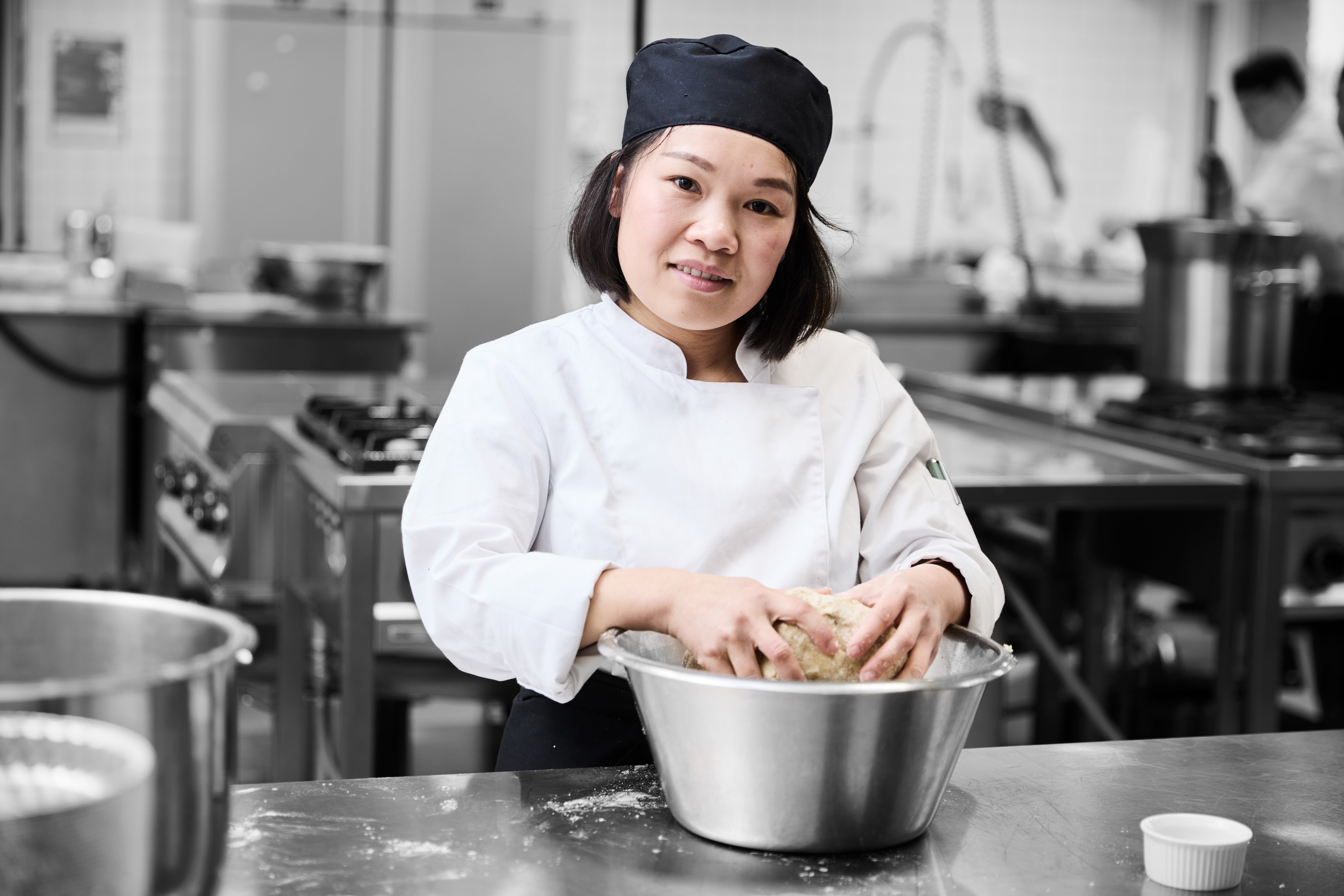 Ernæringsassistent i køkken arbejder med en dej 