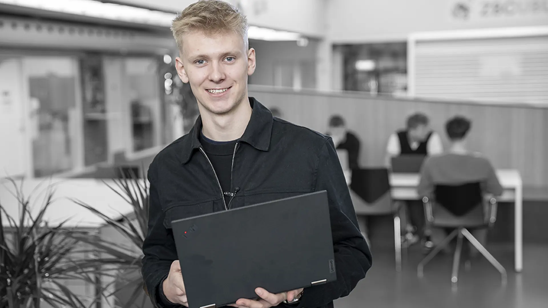Elev på Handelsuddannelsen står med computer