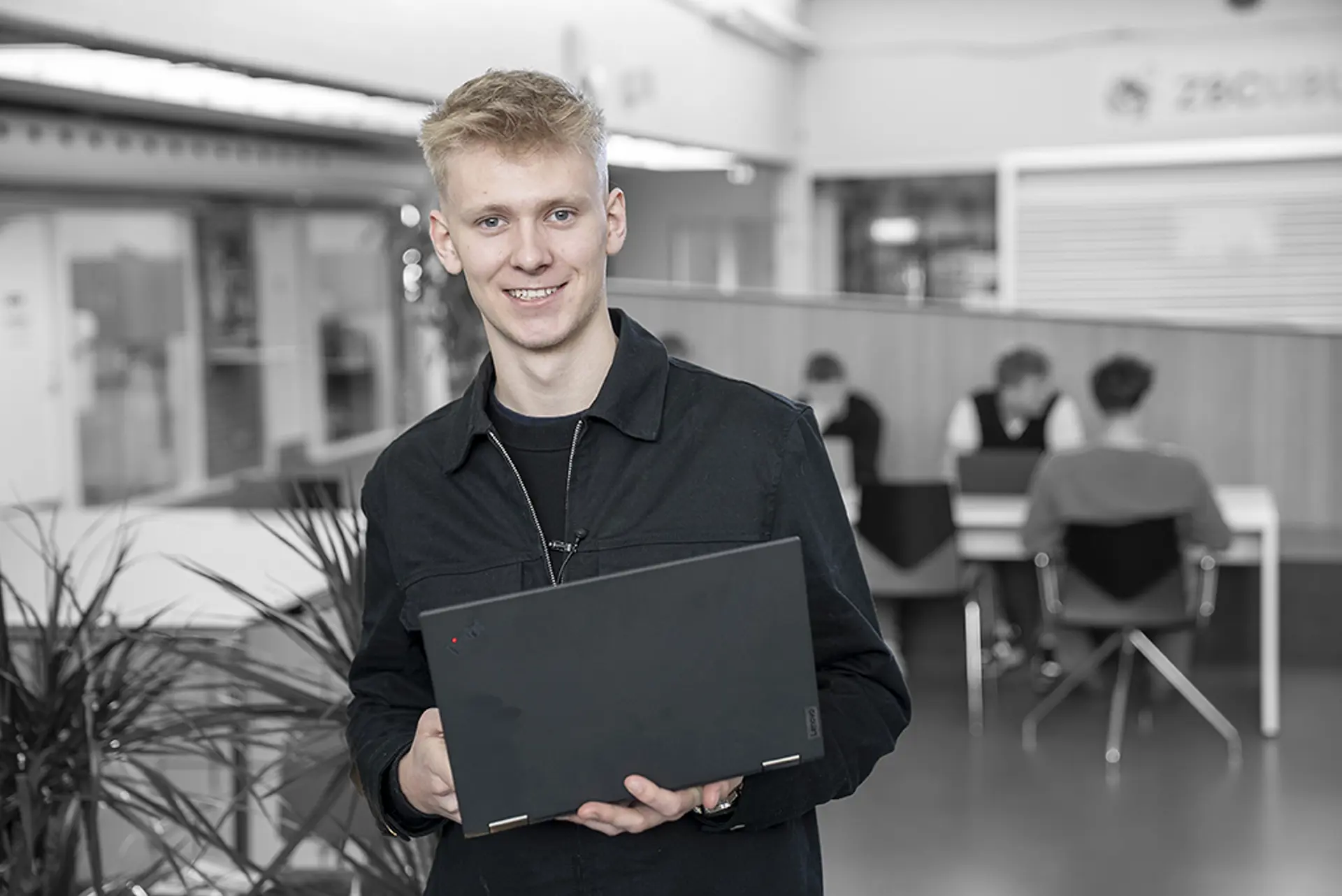 Elev på Handelsuddannelsen står med computer