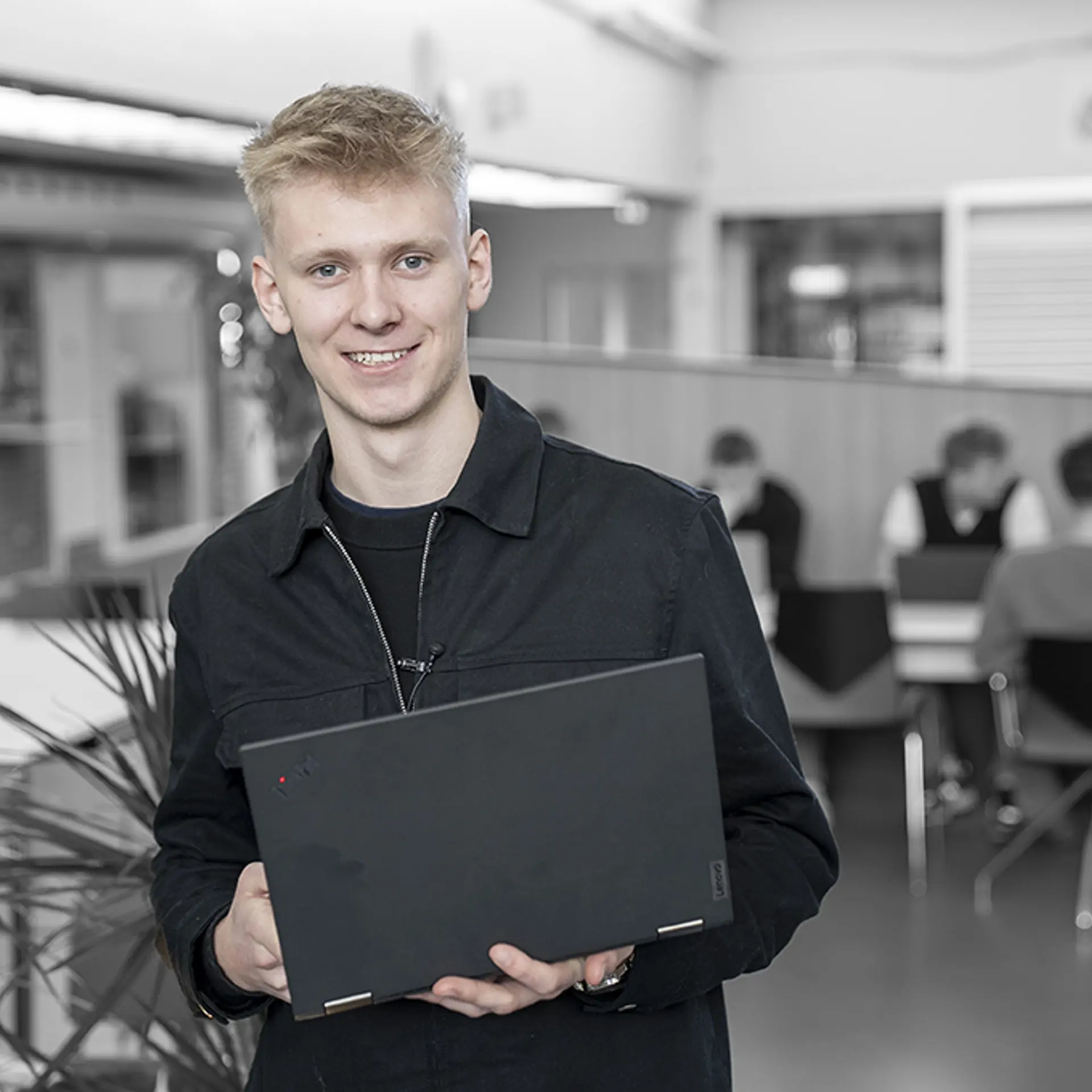 Elev på Handelsuddannelsen står med computer