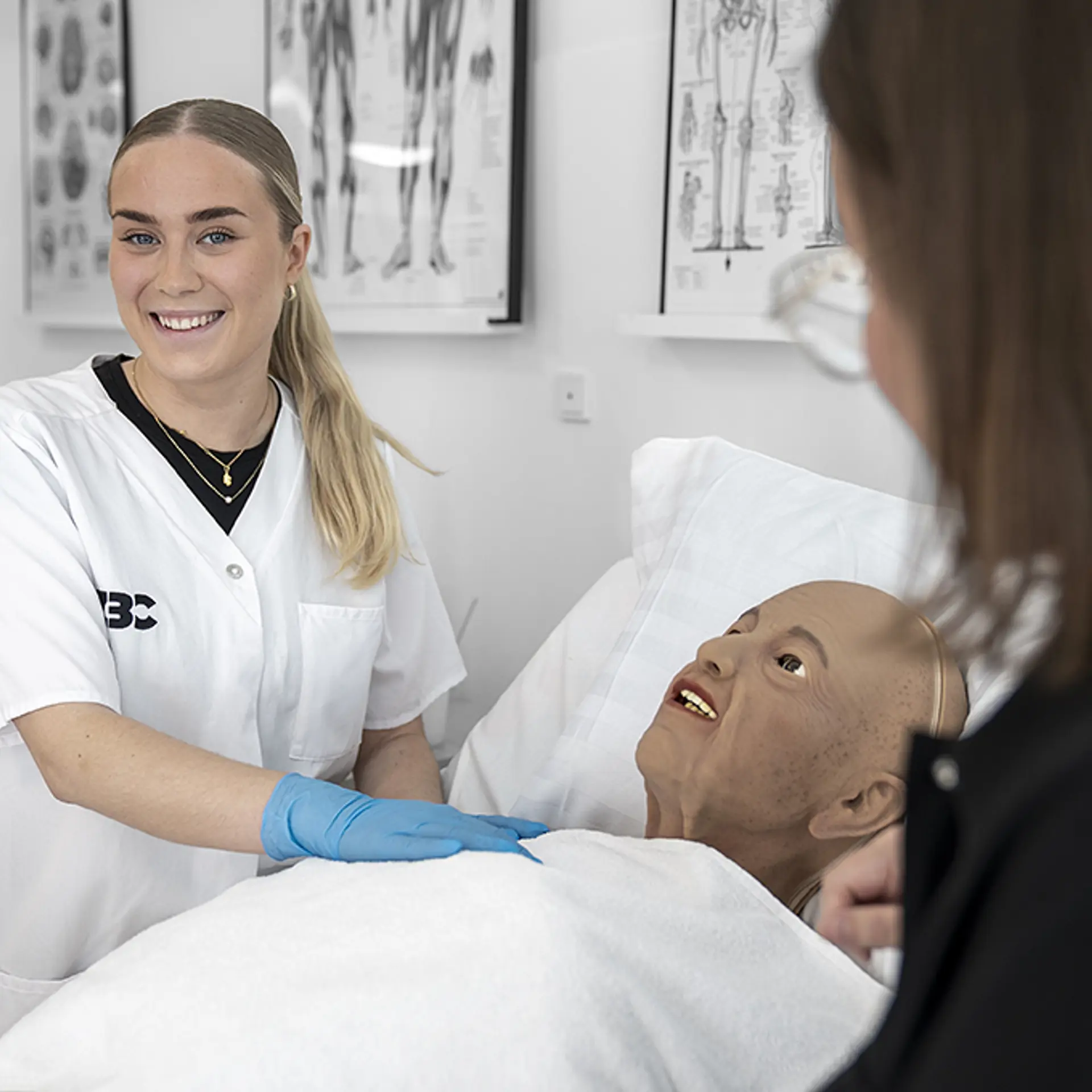Elev fra SOSU- uddannelsen arbejder med omsorg og pleje på robotdukke