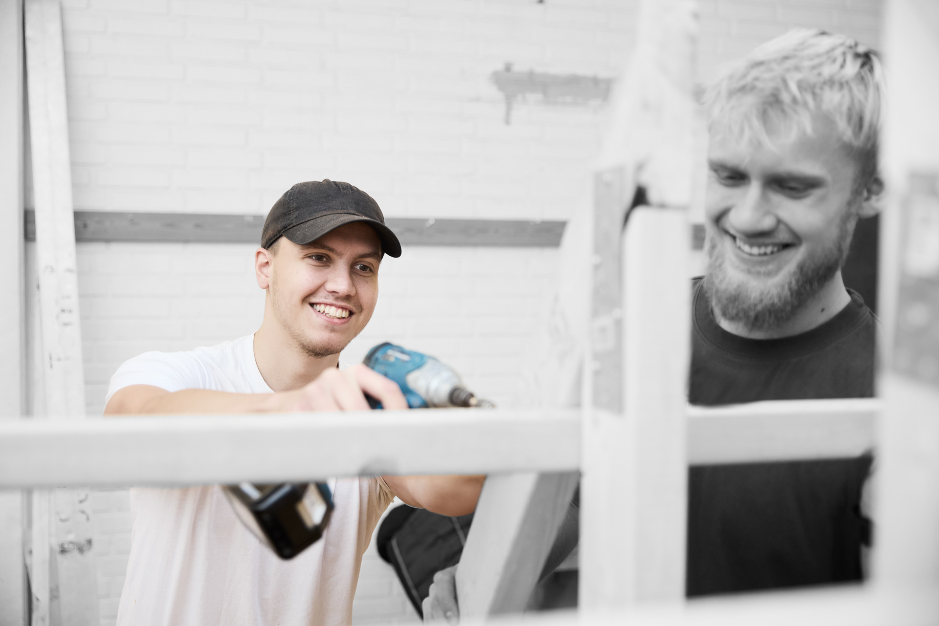 Tømrer borer med boremaskine i en konstruktion