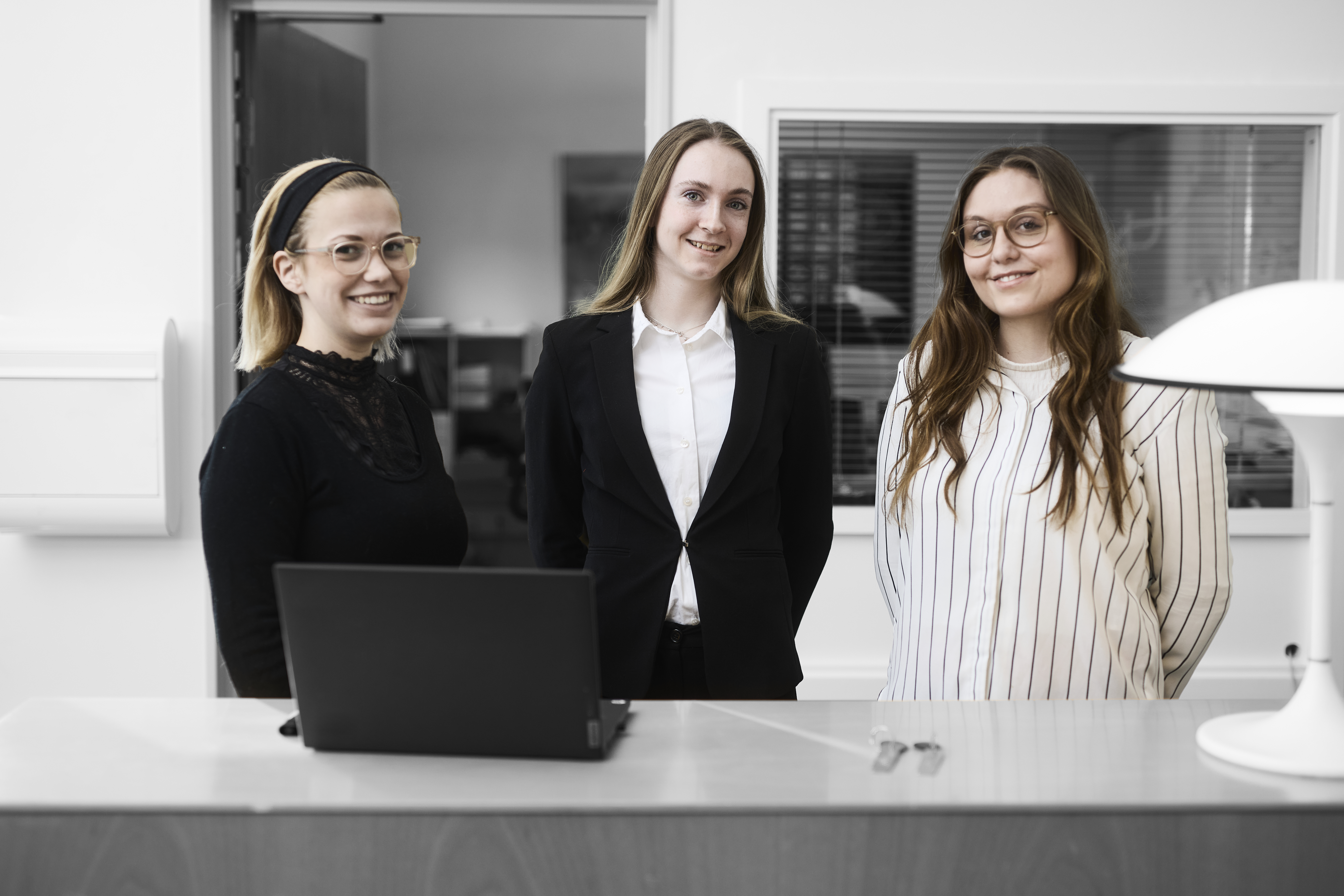 Receptionister står ved skranke