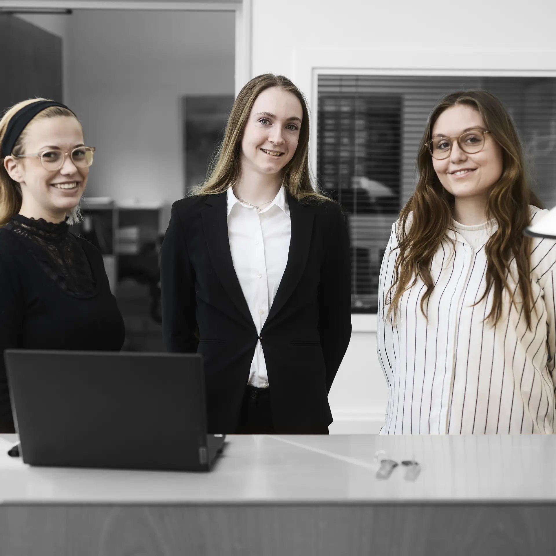 Receptionister står ved skranke