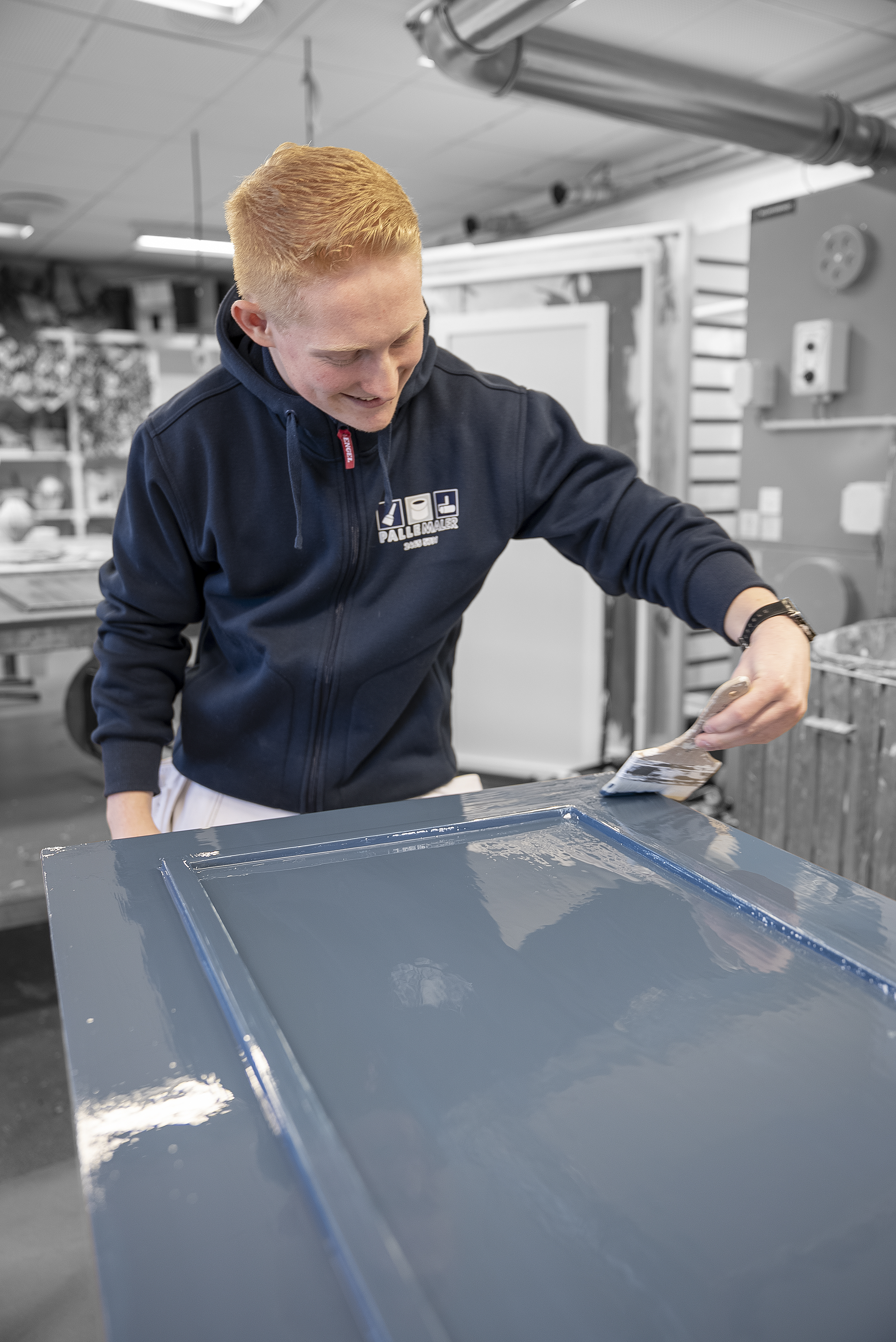 Elev på uddannelsen til bygningsmaler maler dør