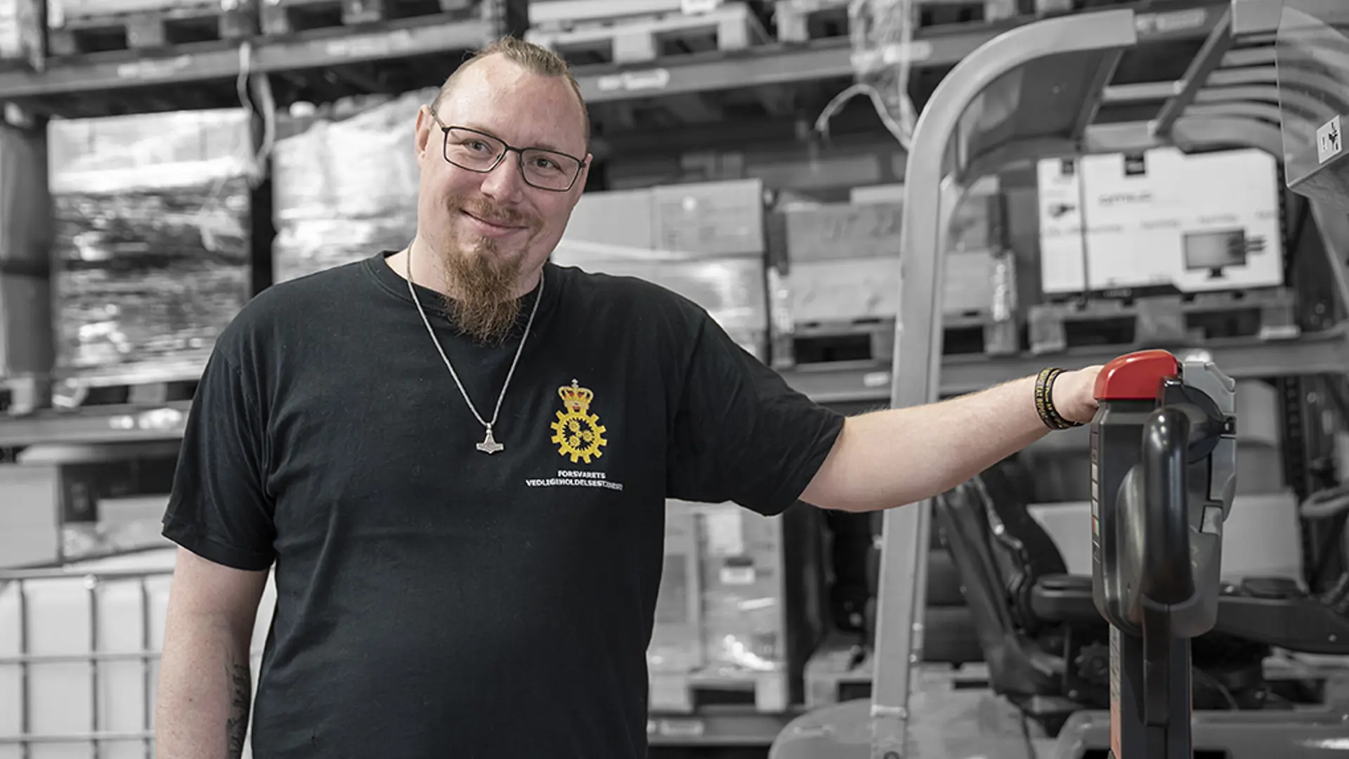 Elev på lager og logistikuddannelsen står med palleløfter i lagerhal
