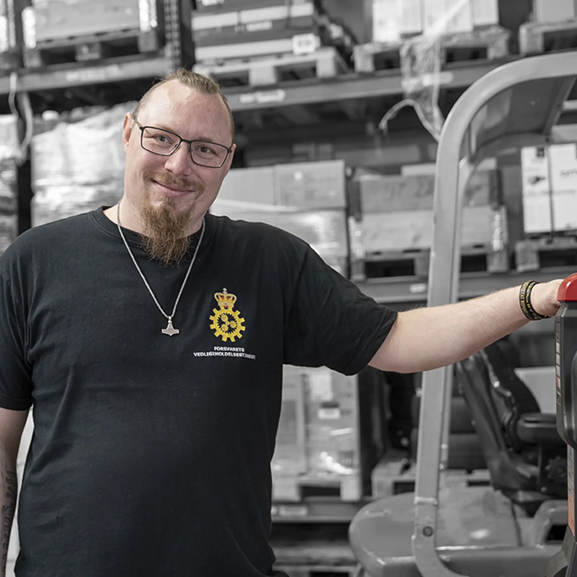 Elev på lager og logistikuddannelsen står med palleløfter i lagerhal