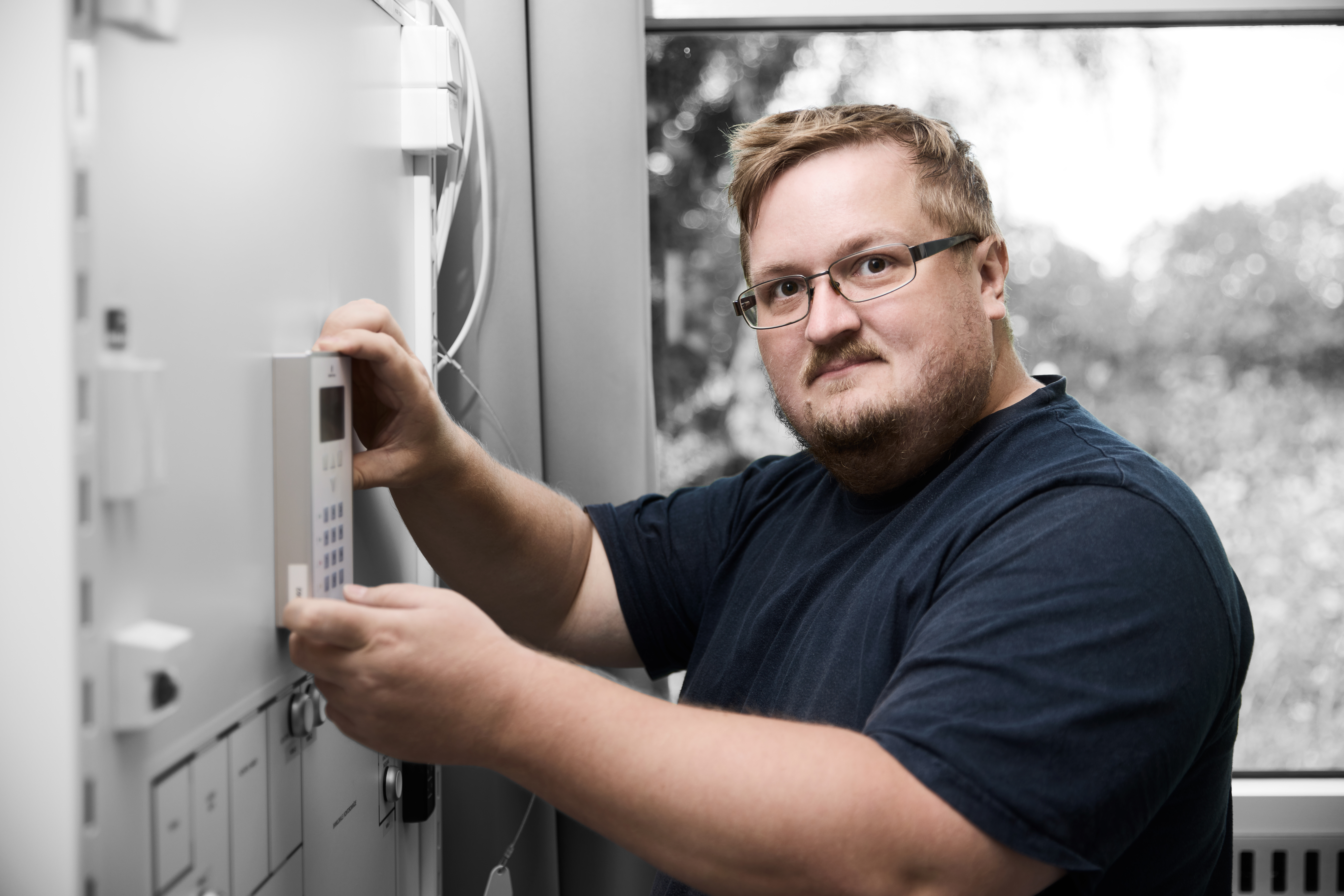 Sikkerhedsvagt står ved alarmsystem