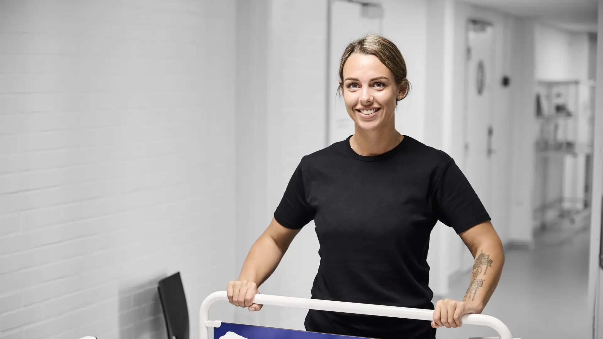 Serviceassistent står ved en hospitalseng