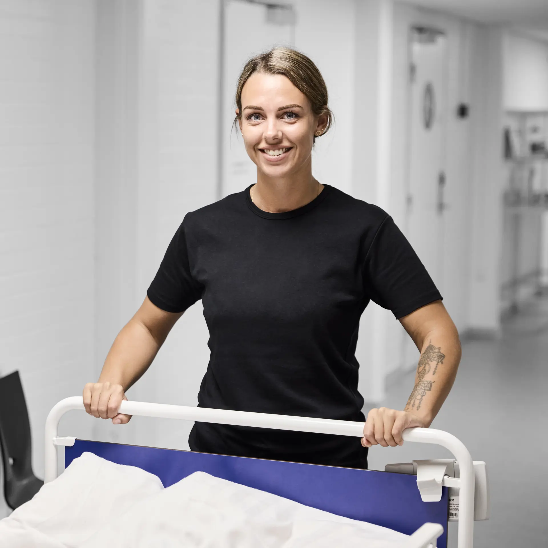 Serviceassistent står ved en hospitalseng