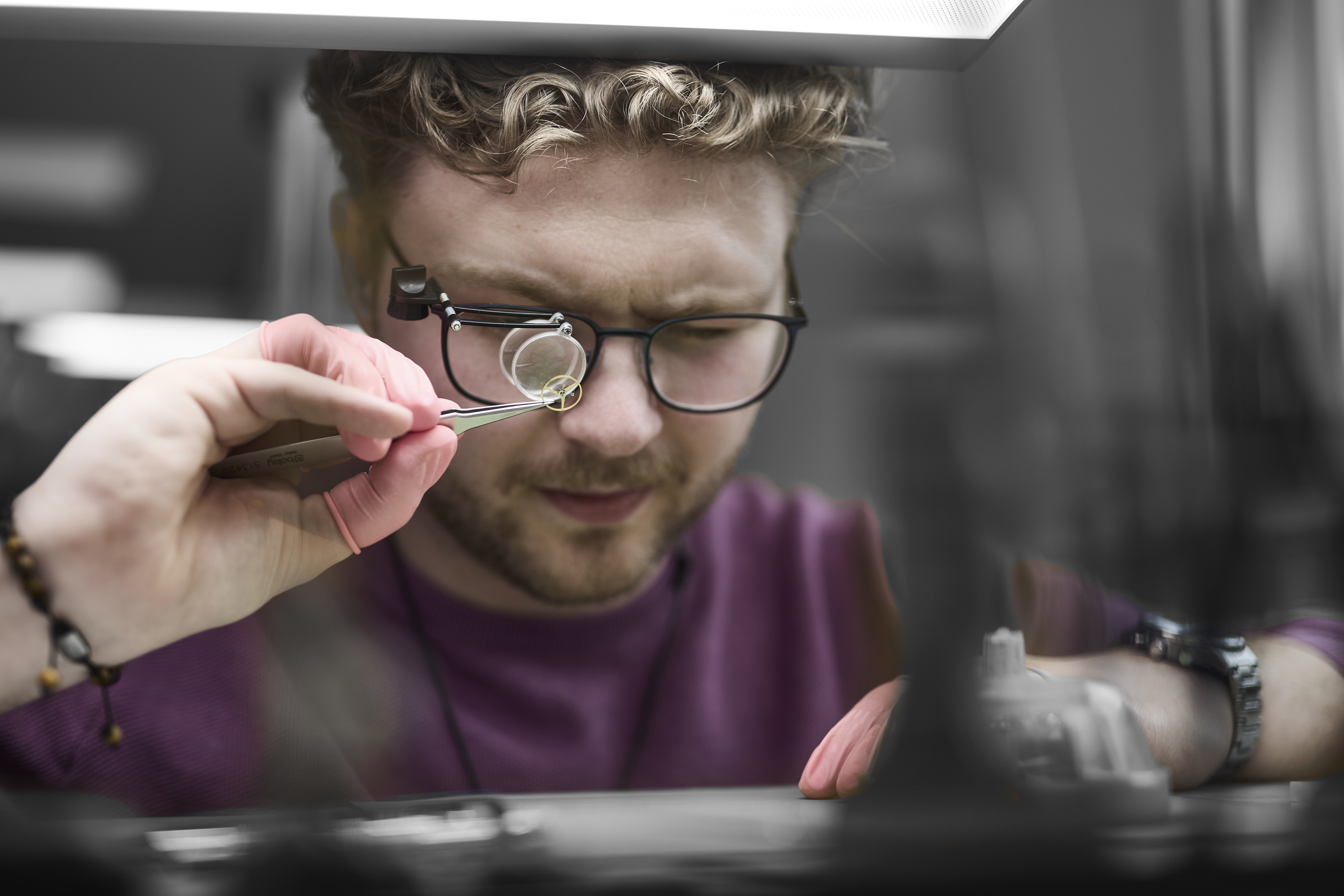 Urmager ser på del fra ur