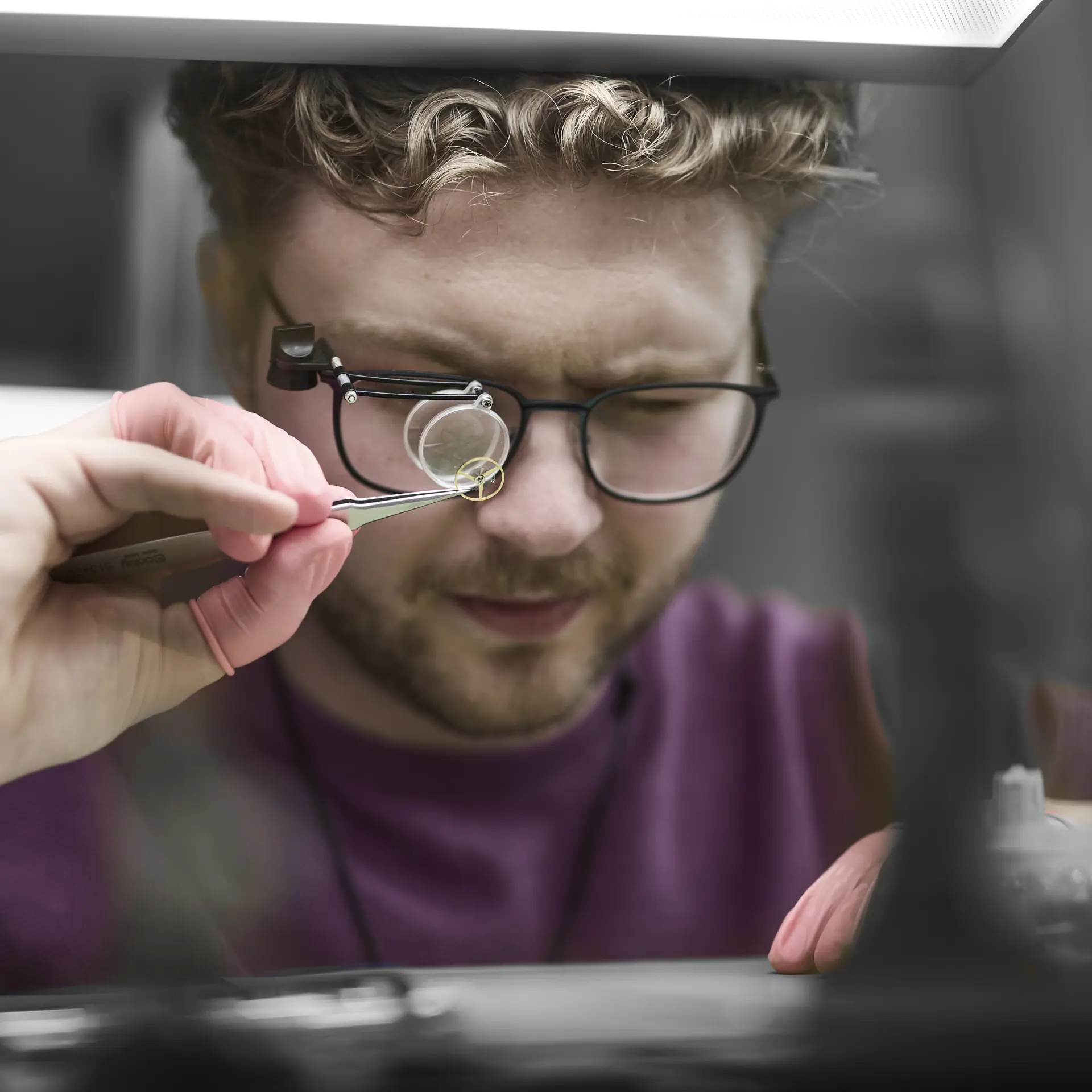 Urmager ser på del fra ur