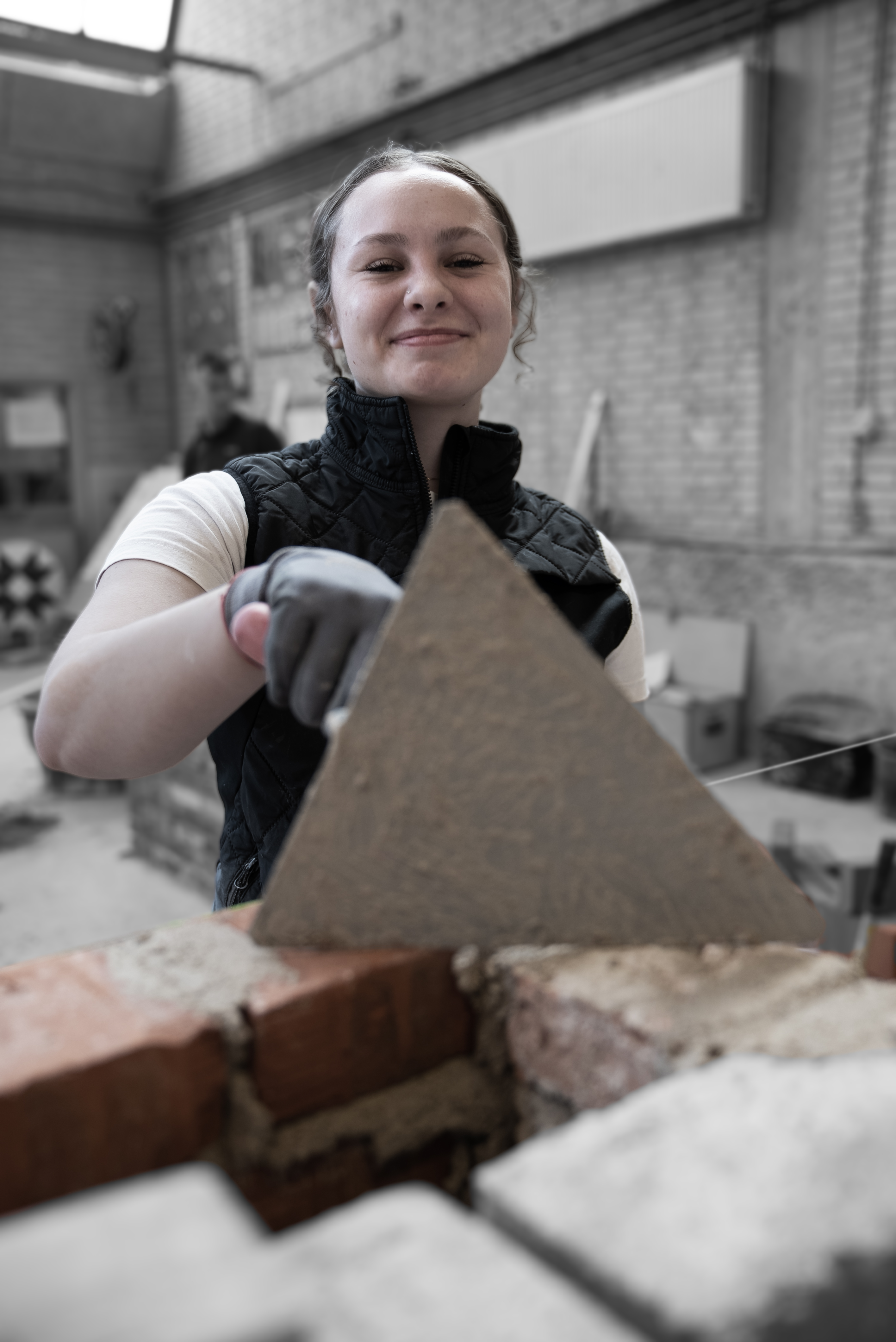 Elev på mureruddannelsen står med murske