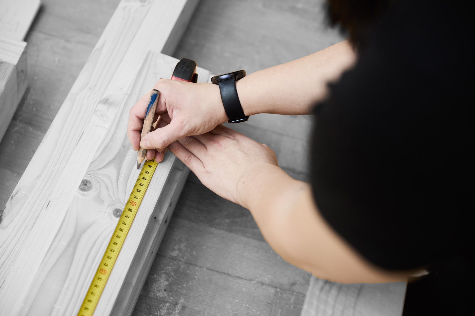 Tømrer måler et stykke træ