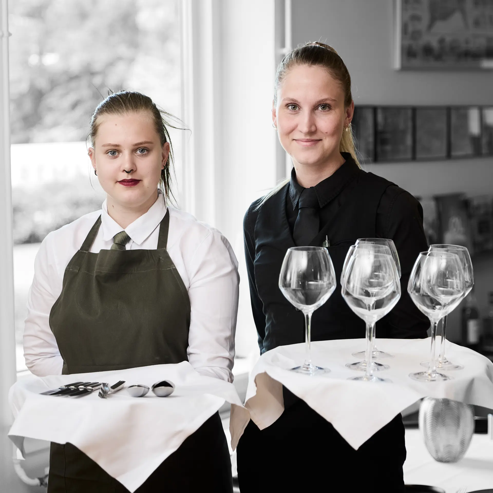 Tjenere står med hver deres bakke