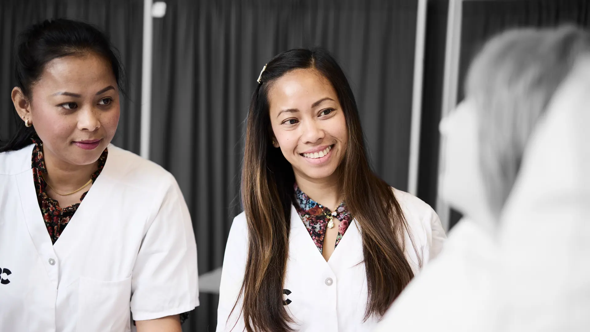 Social- og sundhed: elever står ved en hospitalseng, hvor de smiler til en patient