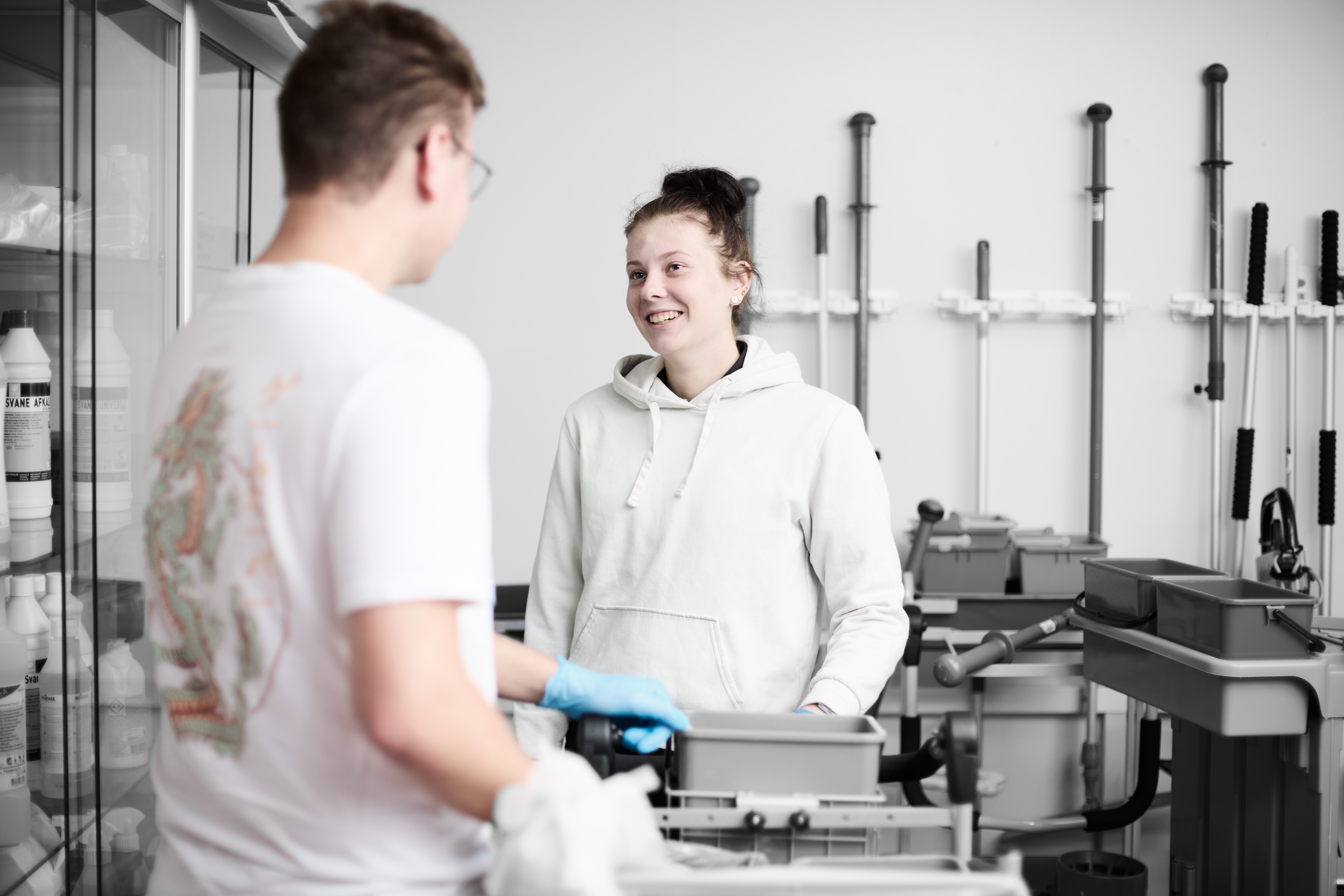 Serviceassistent smiler til anden elev