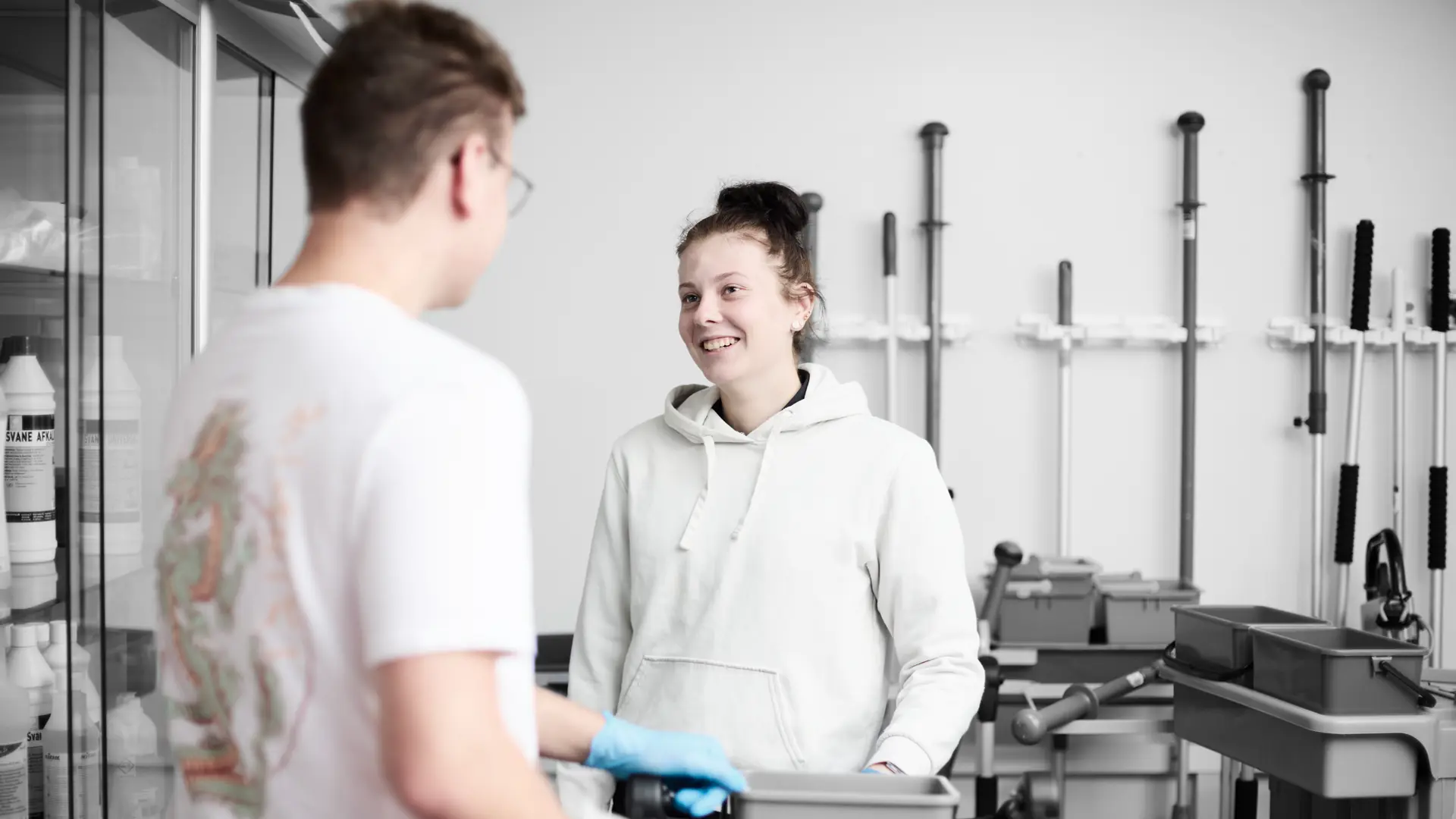 Serviceassistent smiler til anden elev