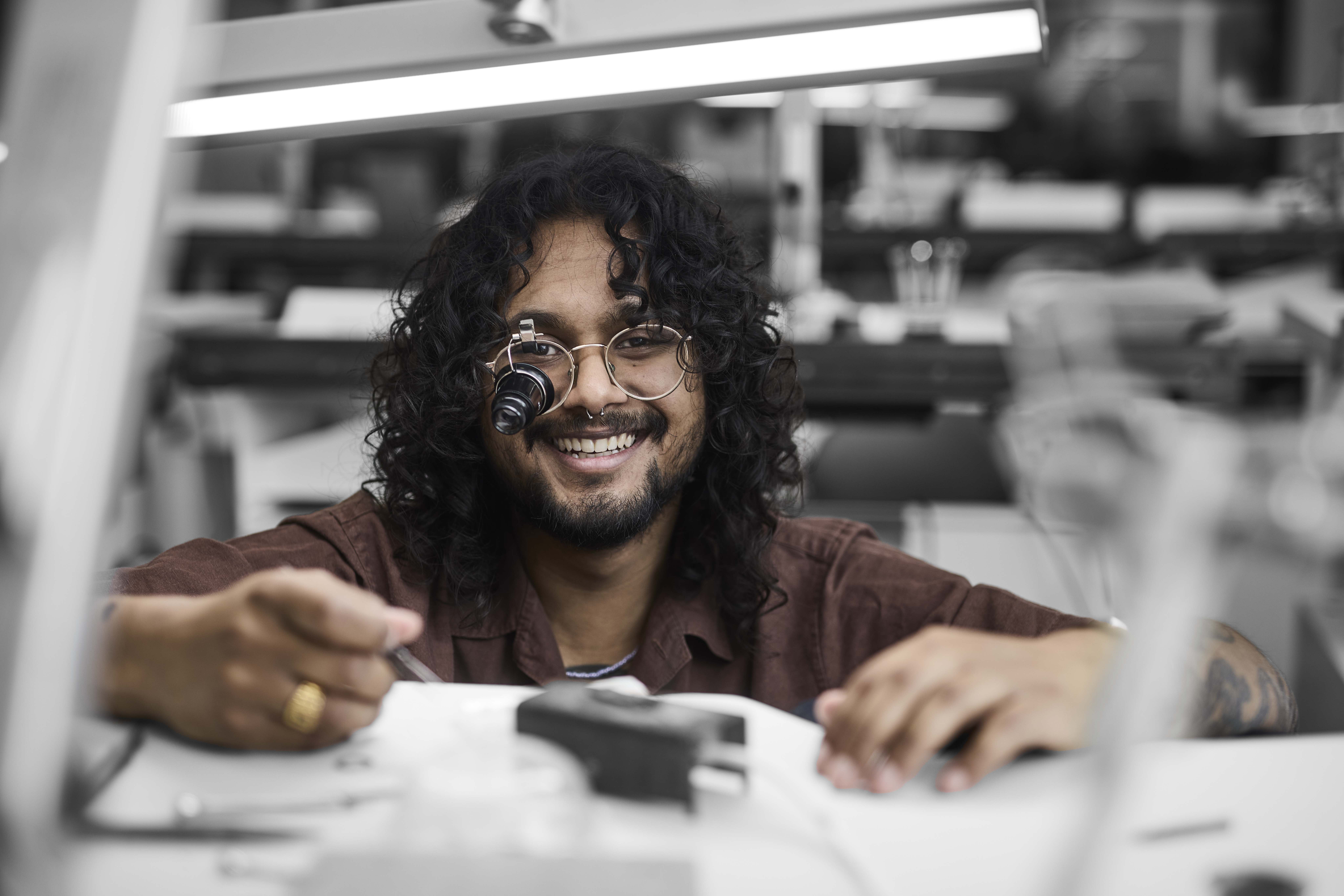 Urmager arbejder med urværk ved et bord
