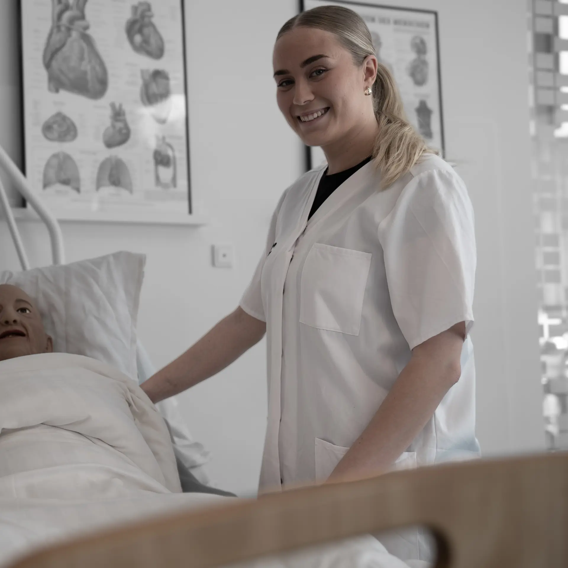 Elev på social- og sundhedsassistentuddannelsen i træningslokale med dukke